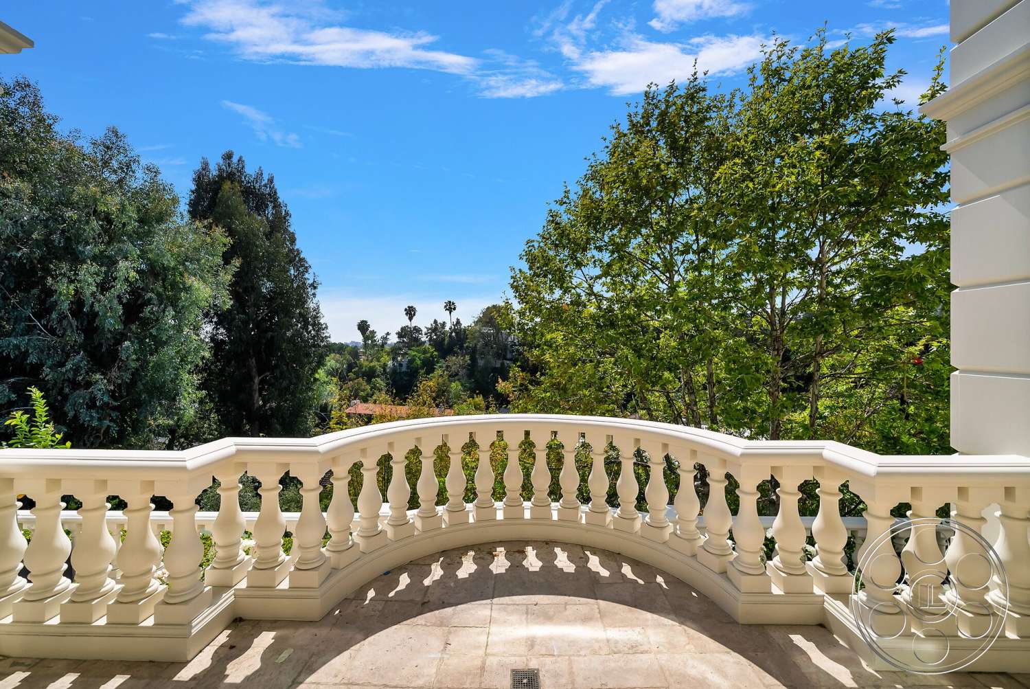 Medit 171 - lush greenery, landscape view, blue sky, palm trees in background, exterior balcony, curved balcony design, stone floor tiles, white stucco railing