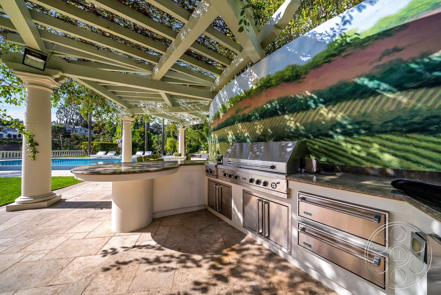 Medit 171 - exterior, in-ground swimming pool, landscaped garden area, granite kitchen countertop, stone patio flooring, stainless steel outdoor kitchen appliances, column supports, pergola with green wooden beams, painted mural on outdoor wall