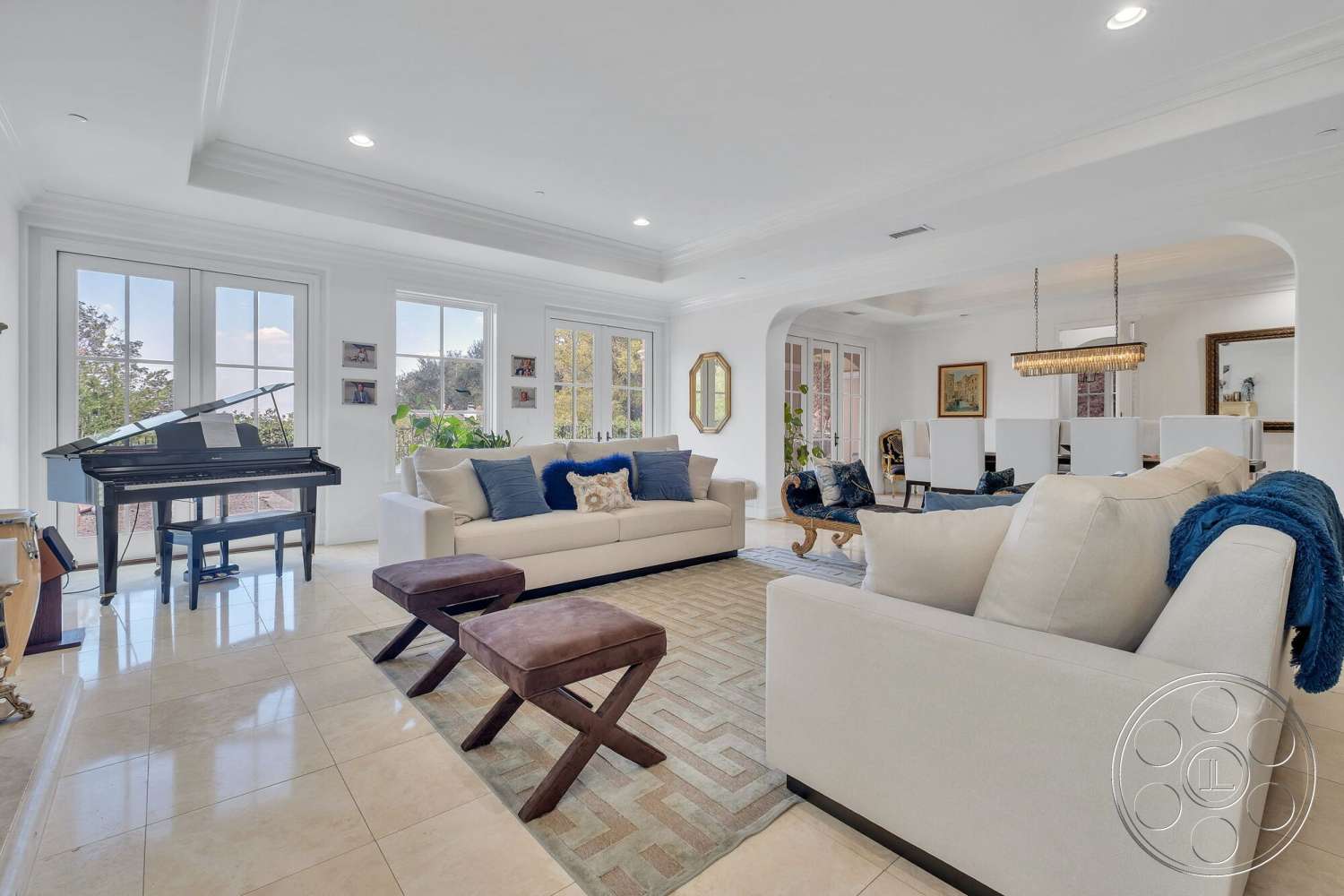 Medit 172 - coffered ceiling, open floor plan, black grand piano, decorative wall art, cream-colored walls, polished marble flooring, large floor-to-ceiling windows, elegant pendant lighting, natural light-filled space, rectangular living room layout, neutral-toned sofas with decorative cushions, brown wooden coffee table, midsize area rug with geometric pattern, home office area visible