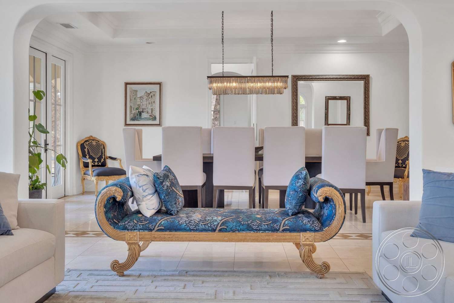 Medit 172 - tile flooring, decorative area rug, gold accents, open concept layout, framed artwork, chandelier lighting, glass door access, elegant dining table, modern dining area, stylish sectional sofa, white painted walls, luxurious upholstery, high back dining chairs, ornate armchair, tray ceiling design