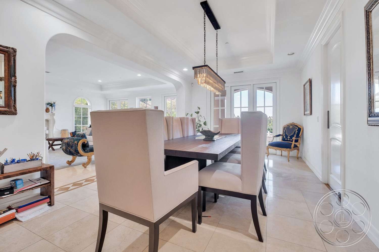 Medit 172 - upholstered dining chairs, wood dining table, large windows for natural light, arched doorways, modern dining space, white painted walls, coffered ceiling details, chandelier with crystal accents, decorative framed wall art, tile dining room flooring, open dining room layout