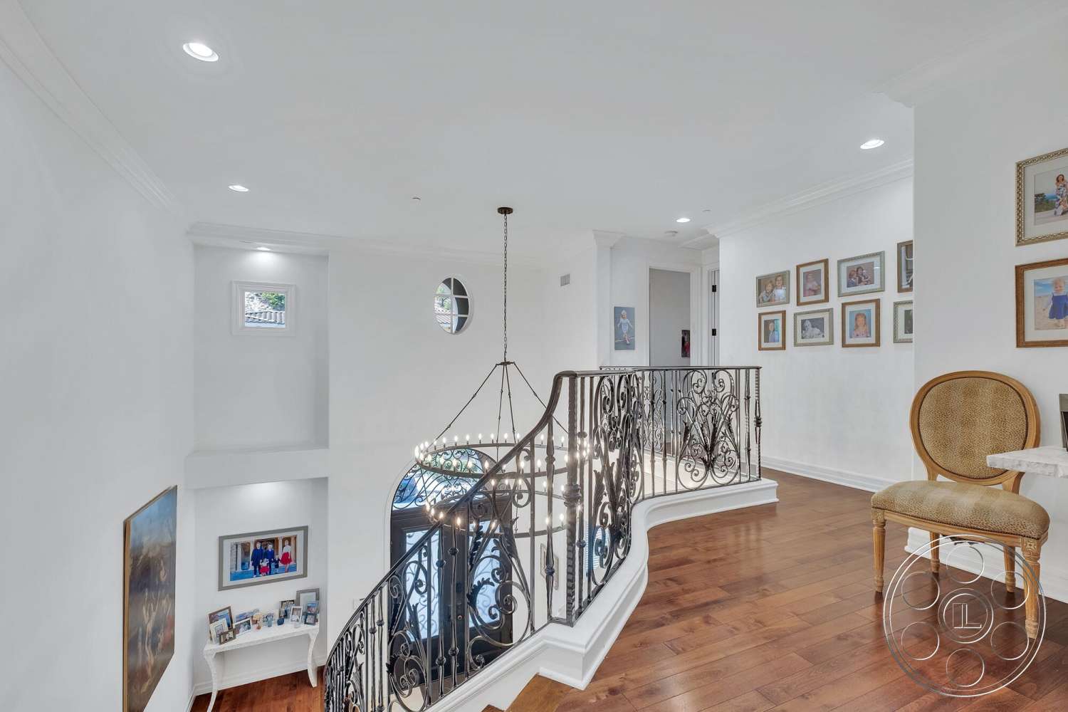 Medit 172 - recessed lighting, vaulted ceiling, dark hardwood flooring, arched doorway, decorative wall frames, white painted walls, chandelier lighting fixture, hardwood staircase, ornate wrought iron balustrade, built-in wall shelf