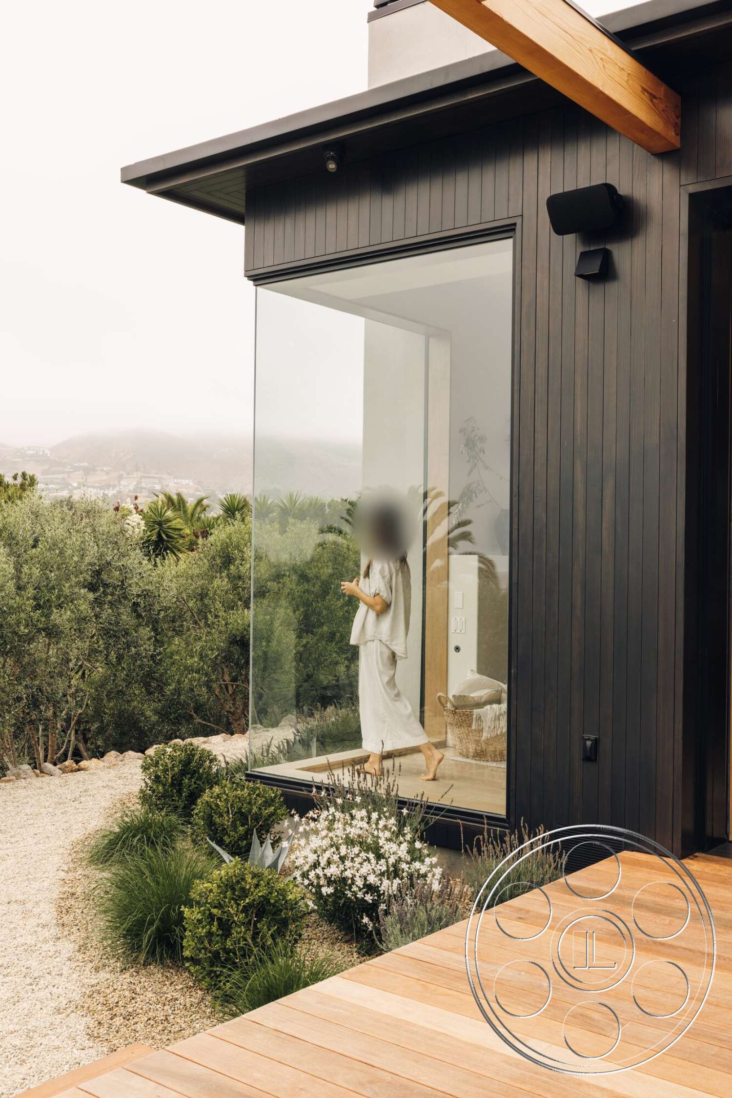Modern 533 - exterior, exposed wooden beams, modern architectural style, gravel landscaping, wooden deck flooring, curved flower beds, floor-to-ceiling glass windows, landscaped garden with shrubs, black horizontal wooden siding
