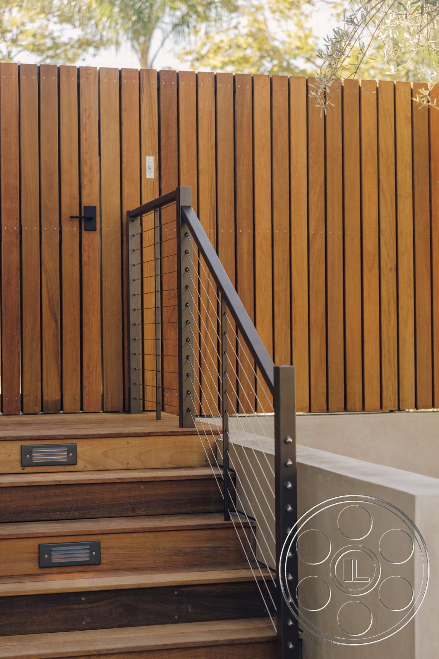 Modern 533 - exterior, wooden staircase, concrete wall, modern architectural style, wooden slatted fence, landscape greenery, outdoor lighting fixtures, textured wood grain, steel stair railing, deck steps