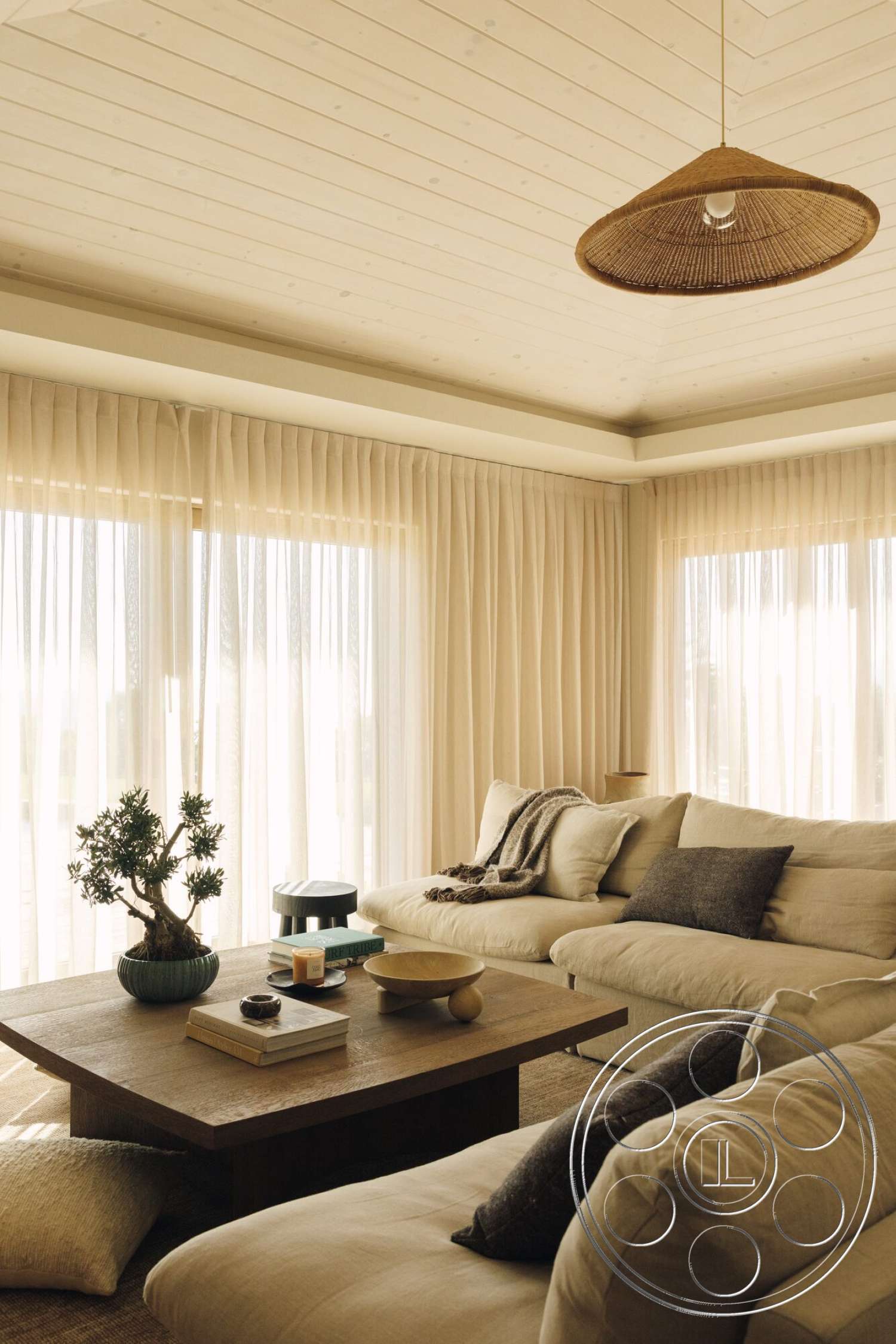 Modern 533 - natural wood accents, neutral area rug, textured throw pillows, decorative indoor plant, dark wood coffee table, beige upholstered sectional sofa, horizontal wood panel ceiling, light-colored wall curtains, modern woven pendant light