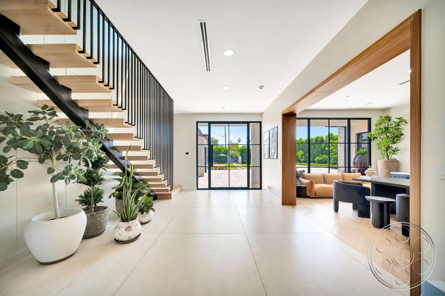 Modern 534 - natural light, minimalist design, concrete flooring, modern aesthetic, textured wall panels, smooth wall finishes, large floor-to-ceiling windows, decorative indoor plants, black metal stair railings, exposed wood staircase, open living area, light-filled entryway, wood framed door opening, angular architectural details