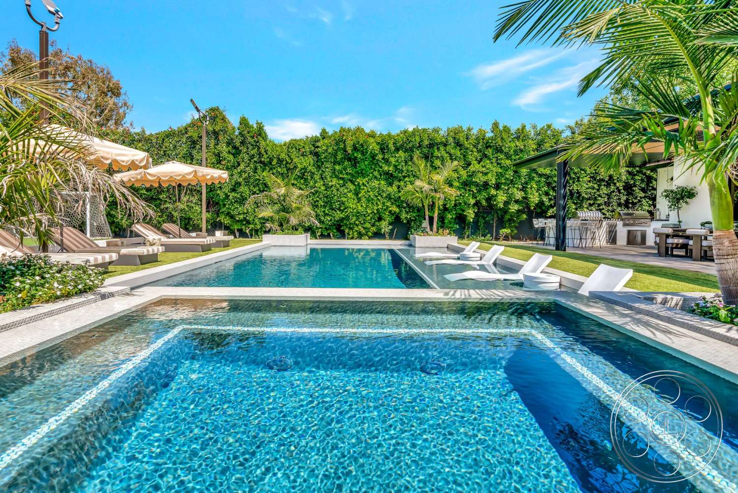 Modern 534 - exterior, landscaped garden, lush greenery, palm trees, outdoor lounge chairs, modern outdoor space, rectangular pool, sunny environment, stone pool deck, concrete pool border, glass patio table, arched umbrella, composite deck, serene backyard setting