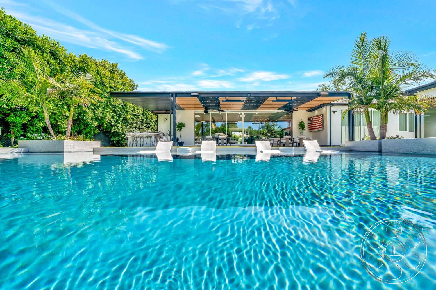 Modern 534 - exterior, palm trees, glass sliding doors, floor-to-ceiling windows, modern architectural style, tropical landscaping, infinity pool, outdoor dining space, concrete pool deck, metal roof, rectangular pool, wood pergola, open patio area
