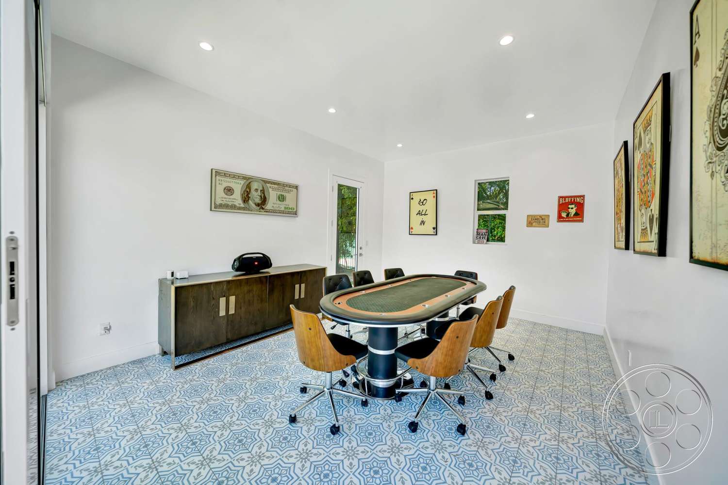 Modern 534 - floor-to-ceiling windows, framed wall art, white painted walls, minimalist lighting fixtures, blue patterned tile flooring, modern poker table, black leather swivel chairs, dark wood cabinet with metal hardware