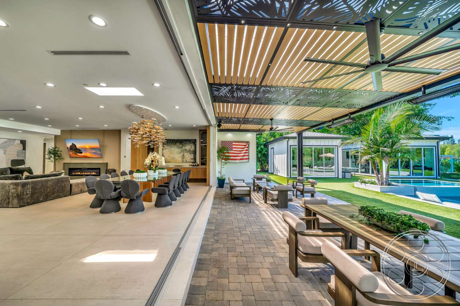 Modern 534 - rectangular swimming pool, contemporary furnishings, concrete planters, lush tropical landscaping, modern pendant light fixture, floor-to-ceiling glass windows, pergola with slatted roof, covered outdoor dining area, large abstract wall art, interior living room with tile flooring, exterior patio area with paver stone flooring, wooden dining table with modern chairs, exposed ceiling with decorative screens, built-in wall cabinetry, fireplace with modern design