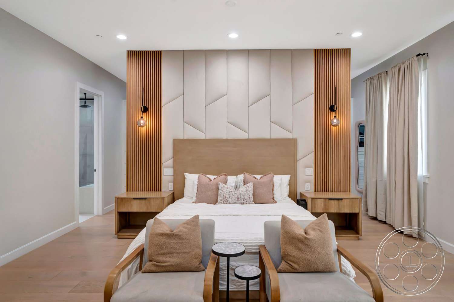 Modern 534 - modern lighting fixtures, textured wall paneling, soft beige wall color, hardwood bedroom floors, contemporary design style, vertical wood slat accent wall, minimalist bedside tables, bedroom with king-sized bed, uplight wall sconces, white bedding with decorative pillows, neutral curtain drapes, open doorway leading to bathroom