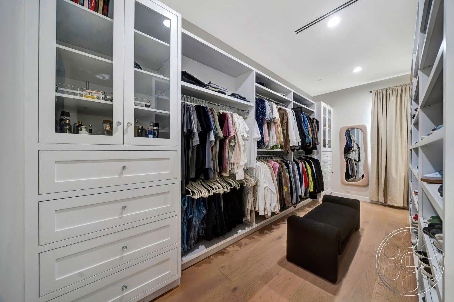Modern 534 - spacious layout, hardwood flooring, contemporary design, neutral wall color, glass-front cabinet doors, built-in shelves, white shaker-style cabinets, clothing organization system, full-length mirror with rounded edges, soft window curtains