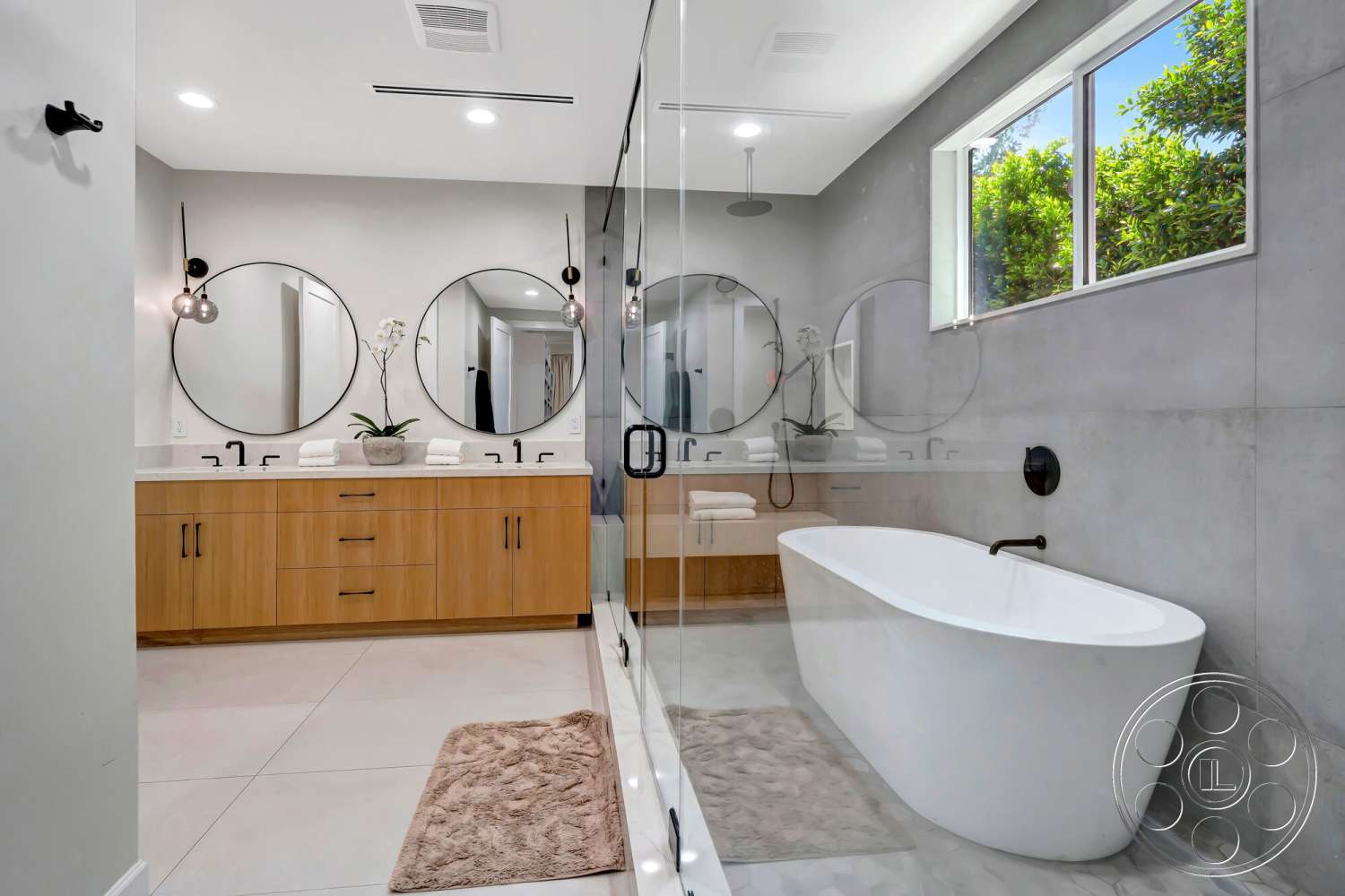 Modern 534 - neutral color palette, freestanding bathtub, glass shower enclosure, modern lighting fixtures, textured plaster walls, white quartz countertop, interior bathroom, wood vanity cabinet, concrete tile flooring, black wall-mounted faucets, circular mirror accent wall