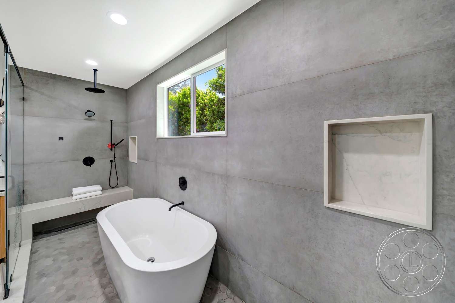 Modern 534 - neutral color palette, recessed lighting, freestanding bathtub, glass shower enclosure, open shower area, hexagonal tile flooring, large window view, minimalist bathroom design, polished concrete walls, white bath towels, black matte shower fixtures, built-in marble niche