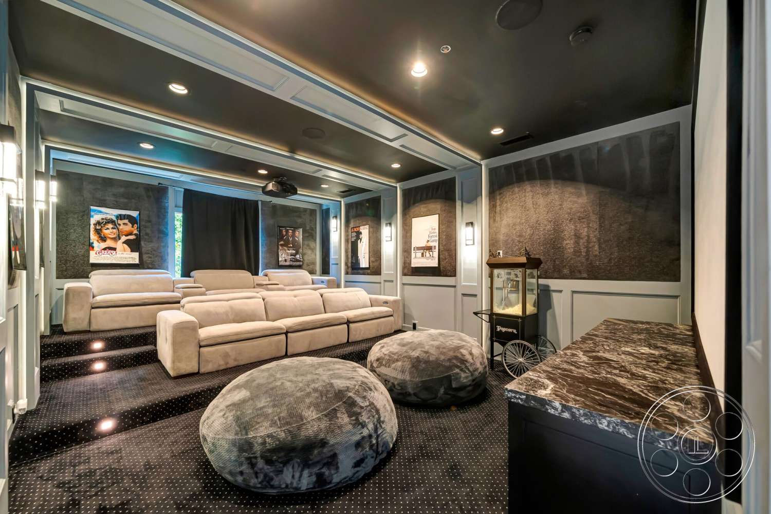 Modern 534 - plush sectional sofa, marble countertop, ambient lighting fixtures, black carpet flooring, built-in cabinets, decorative movie posters, home theater room, dark wall panels, projector ceiling, bean bag seating, staggered seating steps