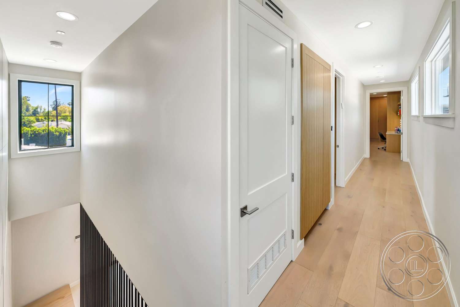 Modern 534 - natural light, light hardwood flooring, floor-to-ceiling windows, modern architectural style, interior hallway, white painted walls, flat panel interior doors, black vertical slat wall treatment
