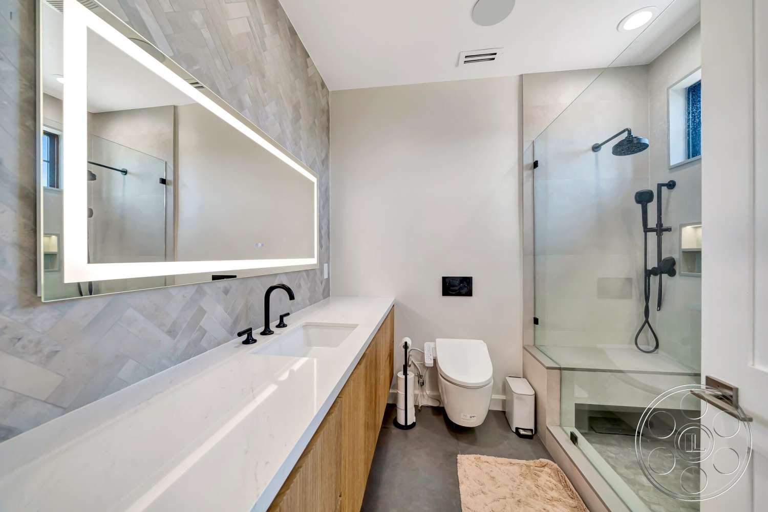 Modern 534 - glass shower enclosure, laminate flooring, minimalist bathroom design, marble bathroom walls, neutral tile flooring, black wall-mounted faucets, black shower fixtures, floating sink countertop, wood cabinet bathroom vanity, large illuminated mirror, built-in shower shelf