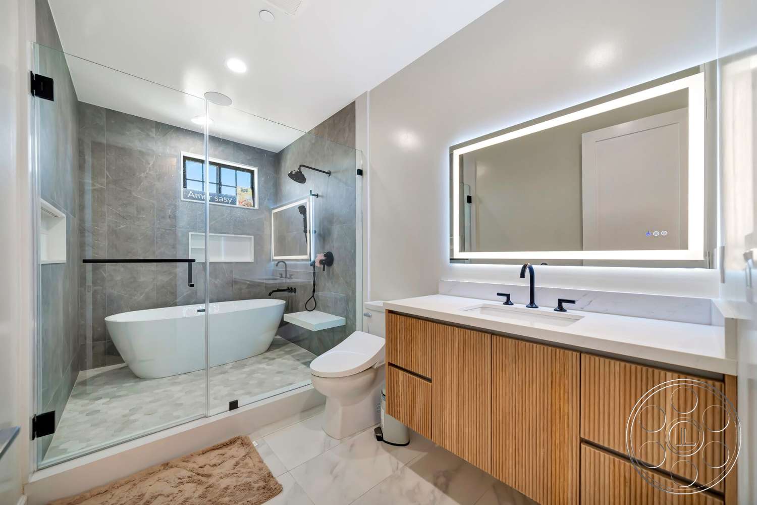 Modern 534 - neutral color palette, glass shower enclosure, marble countertop, textured stone flooring, modern minimalist design, freestanding oval bathtub, tile bathroom walls, black matte faucet fixtures, floating vanity with wood paneling, integrated lighting mirror, brushed steel showerhead, recessed shelving, illuminated mirror