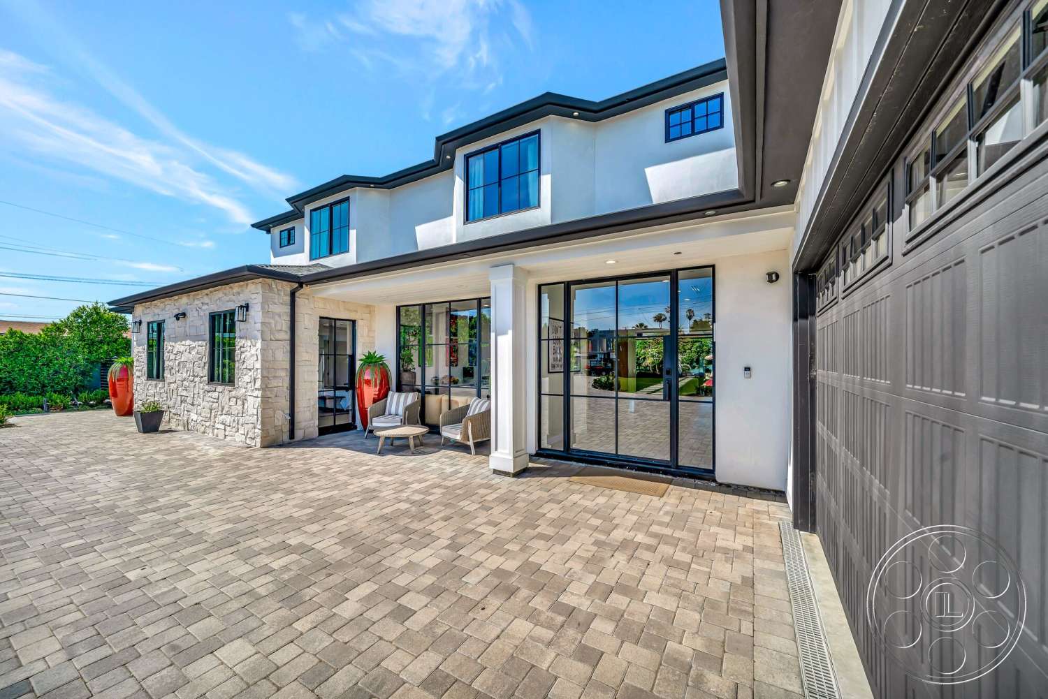 Modern 534 - contemporary style, exterior, landscaped garden, paver driveway, modern outdoor furniture, wooden porch, dormer windows, flat roof design, glass entry doors, stone facade walls