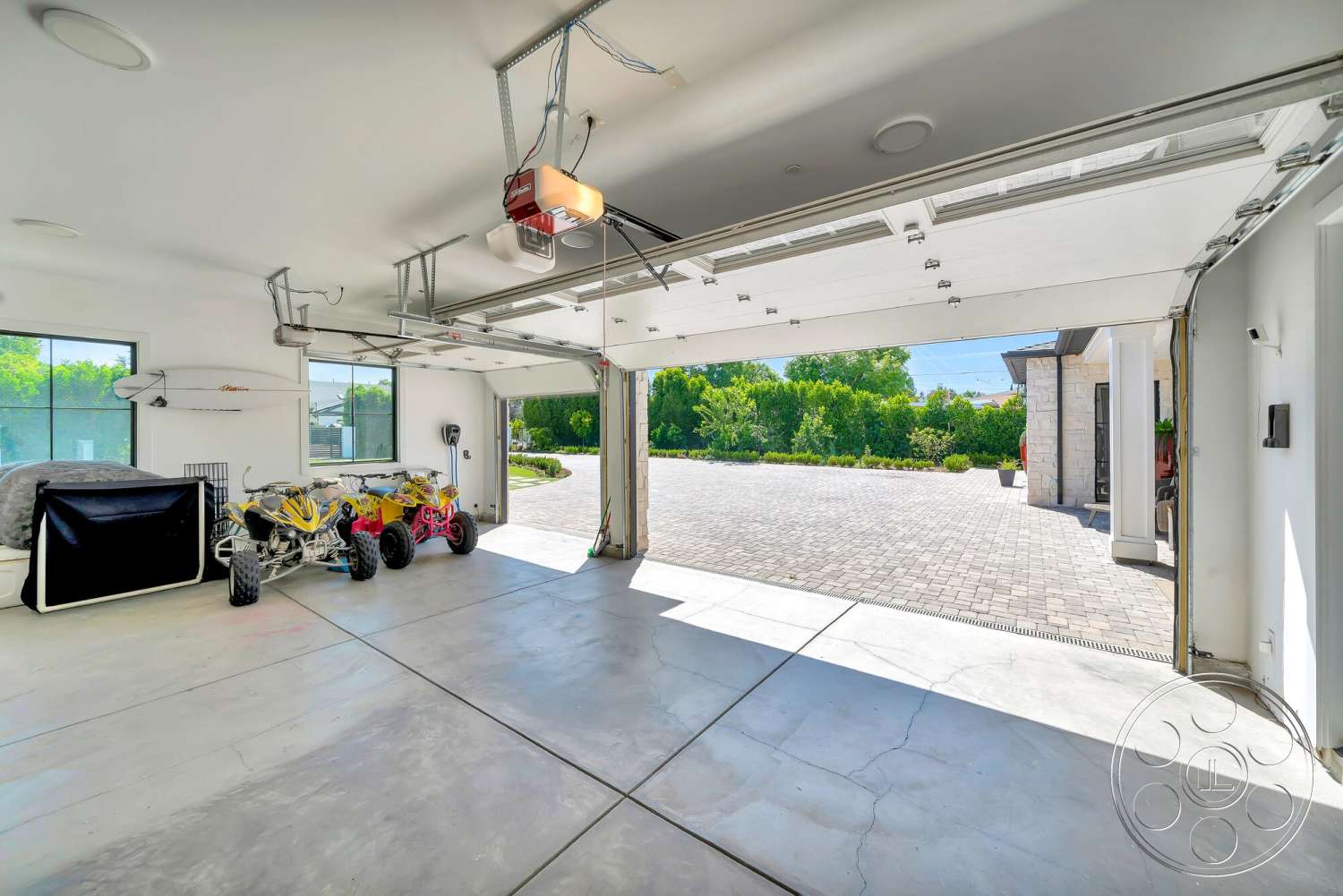 Modern 534 - minimalist decor, paved driveway, high ceiling, floor-to-ceiling windows, exposed light fixtures, roll-up garage door, concrete garage floor, modern garage design