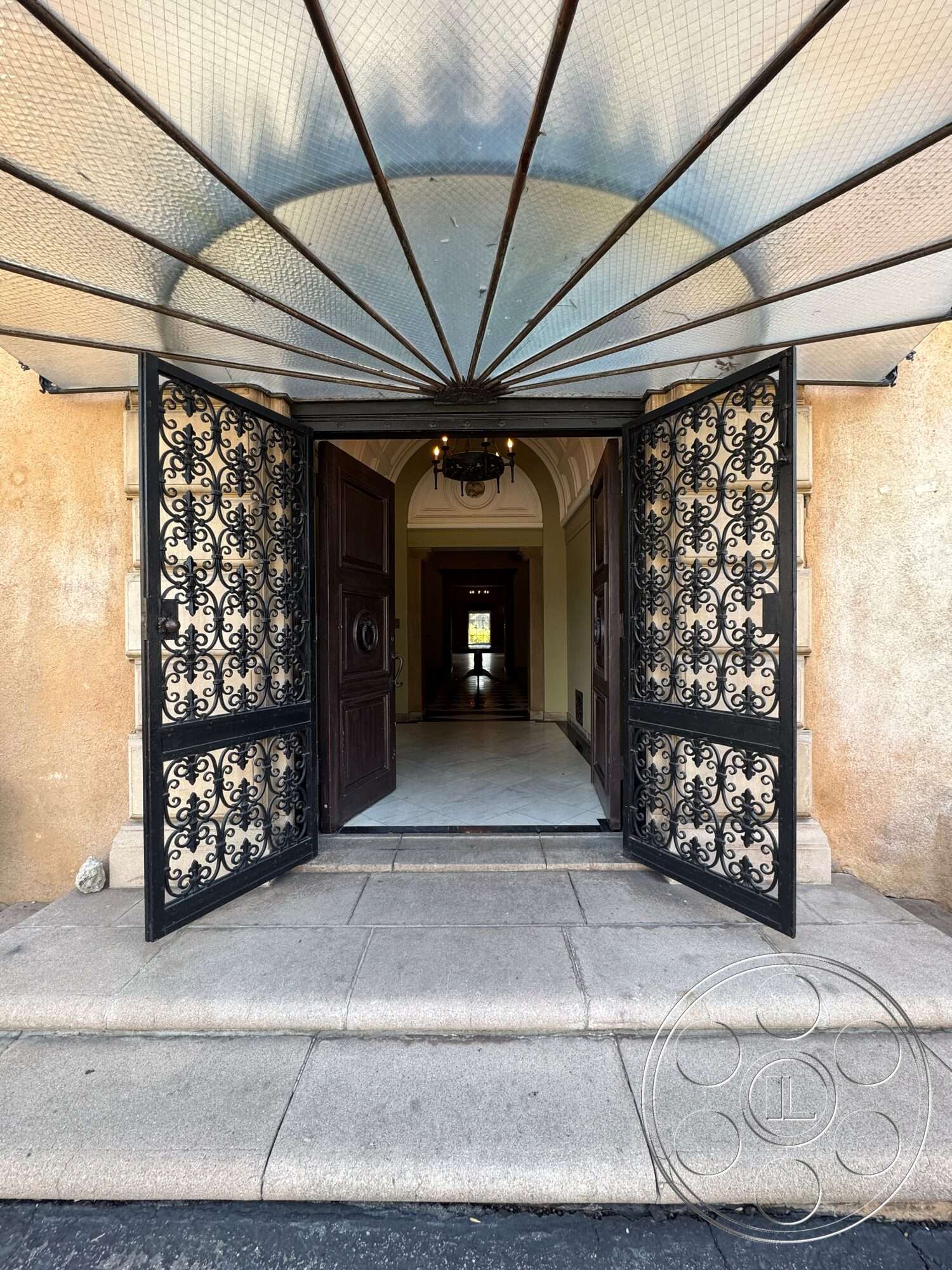 Villa Italy - exterior, arched doorway, arched ceiling, stone steps, exposed brick accent wall, chandelier lighting fixture, symmetrical entrance design, plaster wall finishes, ornate wrought iron doors, marble entryway floor, decorative ceiling canopy