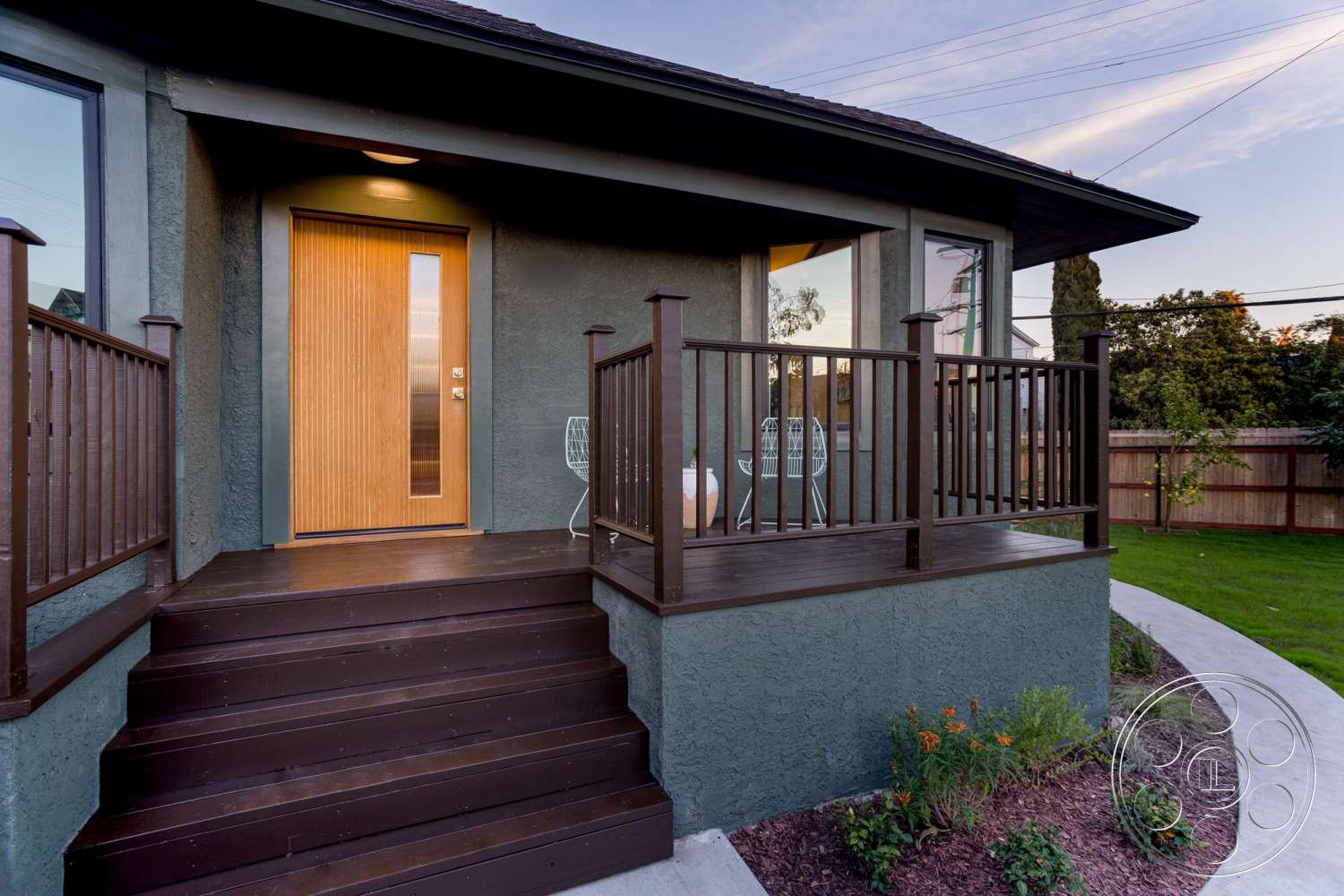 Craftsman 65 - large windows, exterior, green landscape, modern architectural style, concrete walkway, wood front door, horizontal wood slats, textured stucco walls, dark wood deck stairs, decorative wooden railing