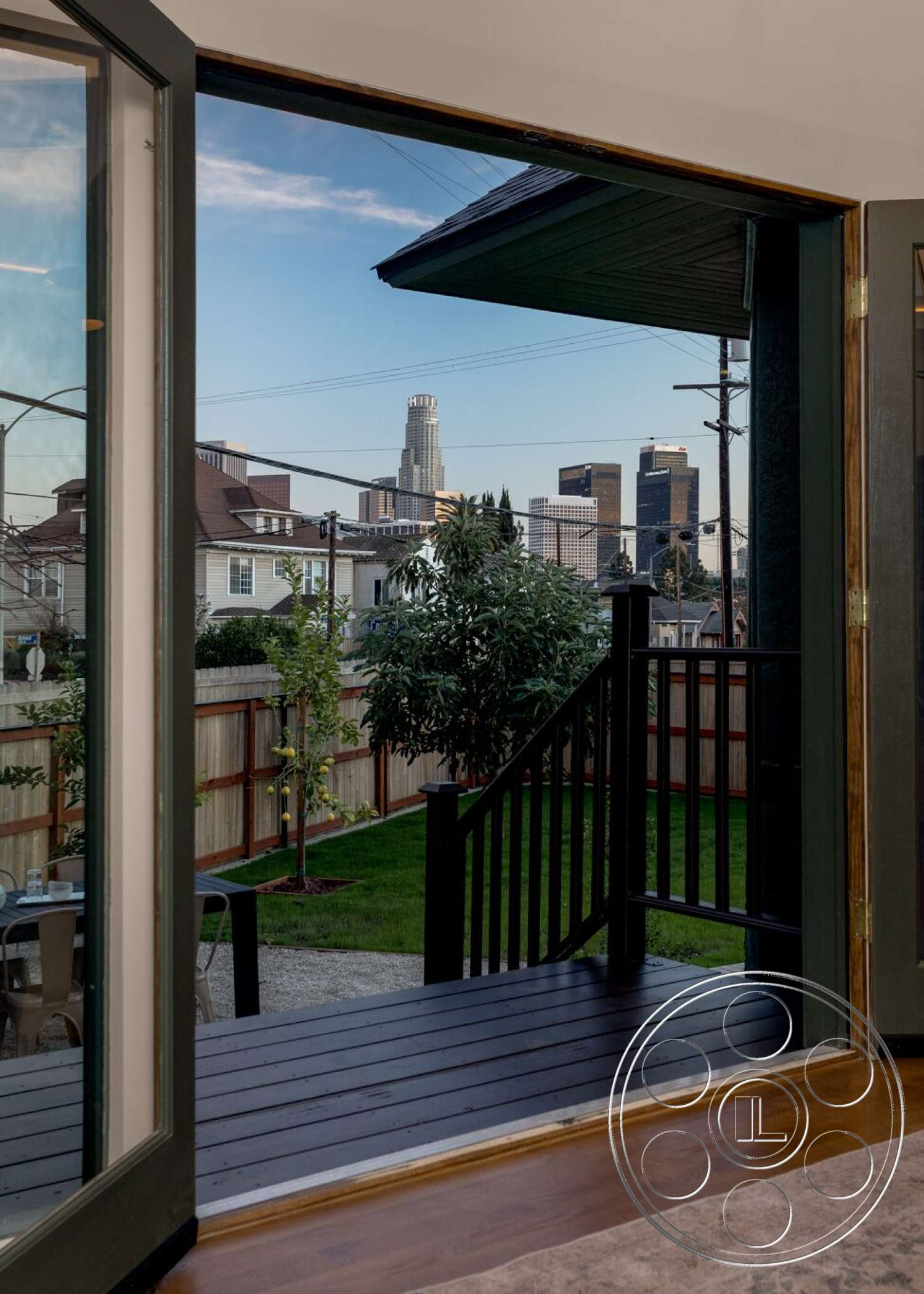 Craftsman 65 - exterior, landscaped garden, wooden steps, concrete patio, green lawn, modern architectural style, glass sliding door, fenced backyard, urban city skyline view, wood deck with railing