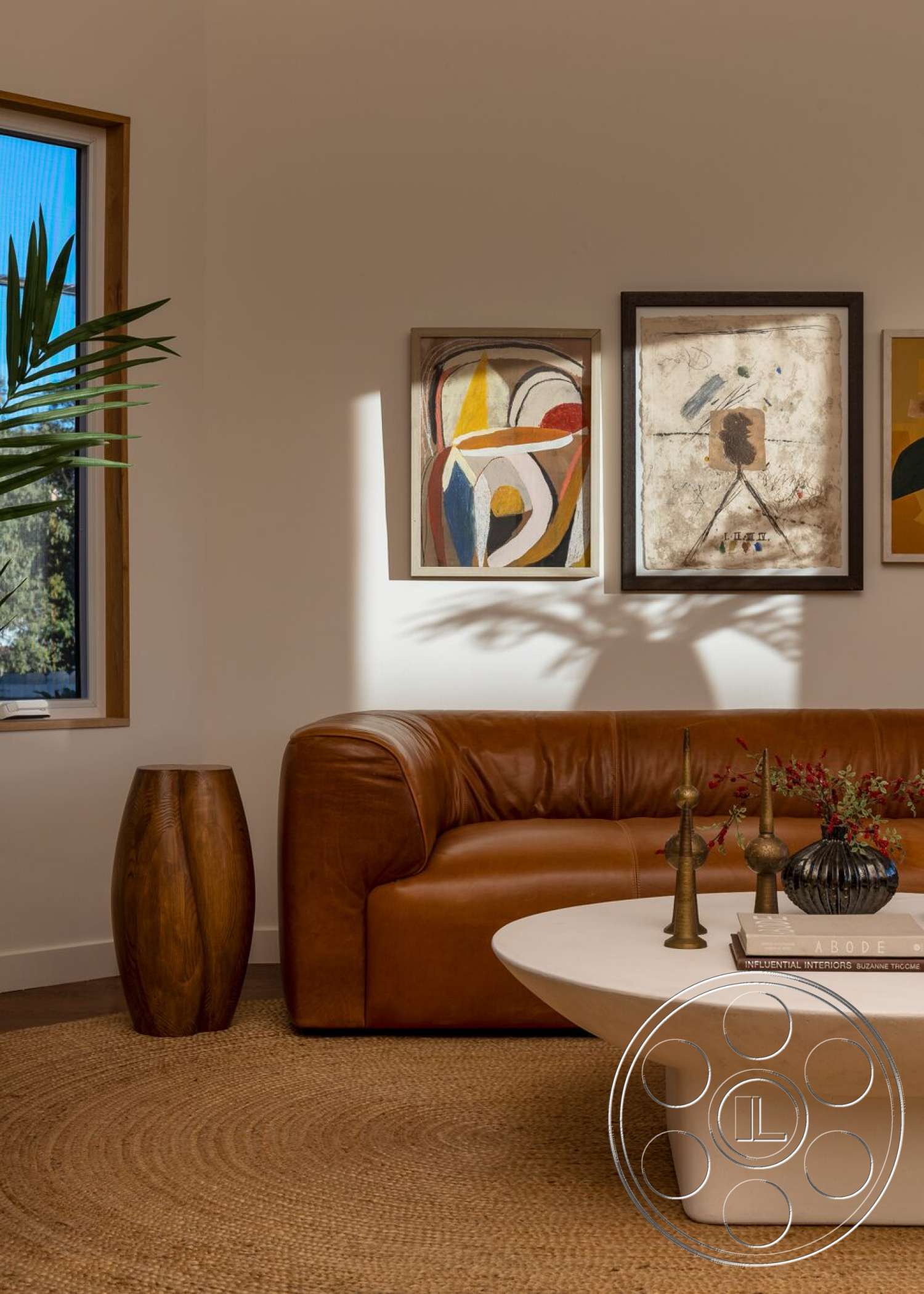 Craftsman 65 - minimalist decor, neutral color palette, plant decor, modern coffee table, woven area rug, leather sofa, natural light from windows, wood window frames, framed abstract artwork, wood side table