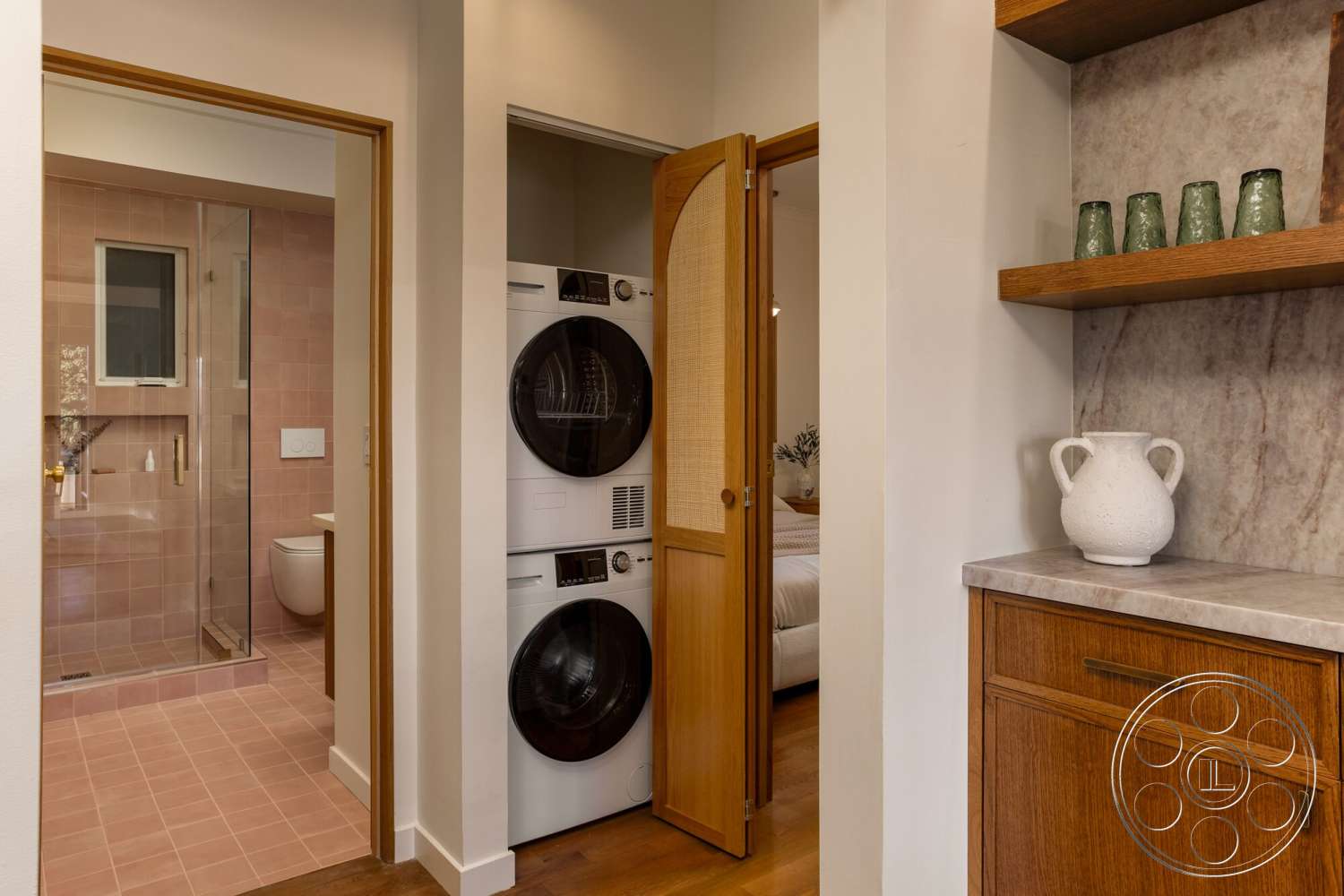 Craftsman 65 - contemporary design, modern bathroom, glass shower enclosure, marble countertop, neutral painted walls, open shelving with decorative objects, wood cabinetry with walnut finish, stacked washing machine and dryer, pink tile flooring, wooden sliding door with cane paneling, laundry nook