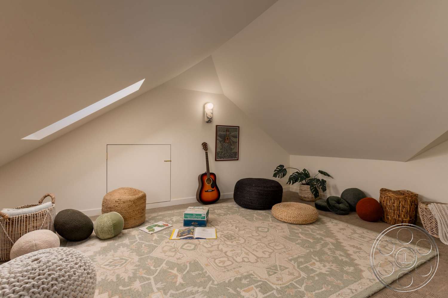 Craftsman 65 - neutral color palette, natural light, plant decor, decorative wall art, sloped ceiling, textured plaster walls, cozy lounge area, woven poufs, skylight window, accent rug, wooden guitar, hidden storage door