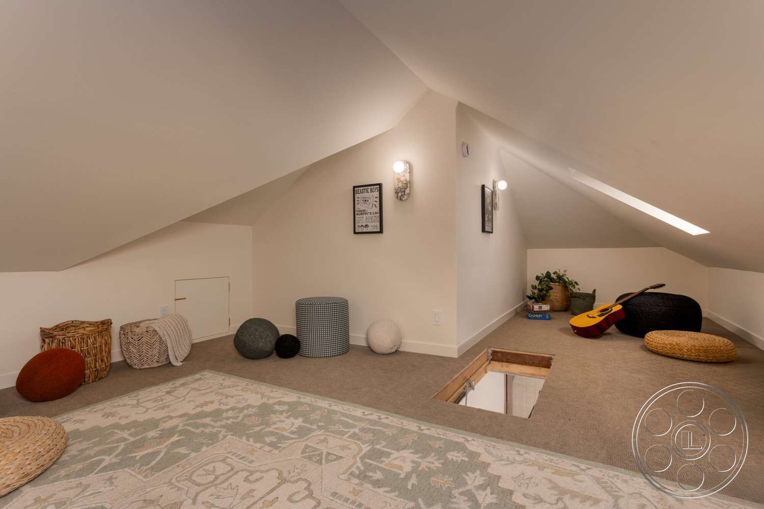 Craftsman 65 - textured area rug, plant decor, exposed wood beams, framed wall art, sloped ceiling, decorative wall sconces, wooden accent features, light-colored painted walls, carpeted floors, various poufs and ottomans, functional attic space, niche storage entry