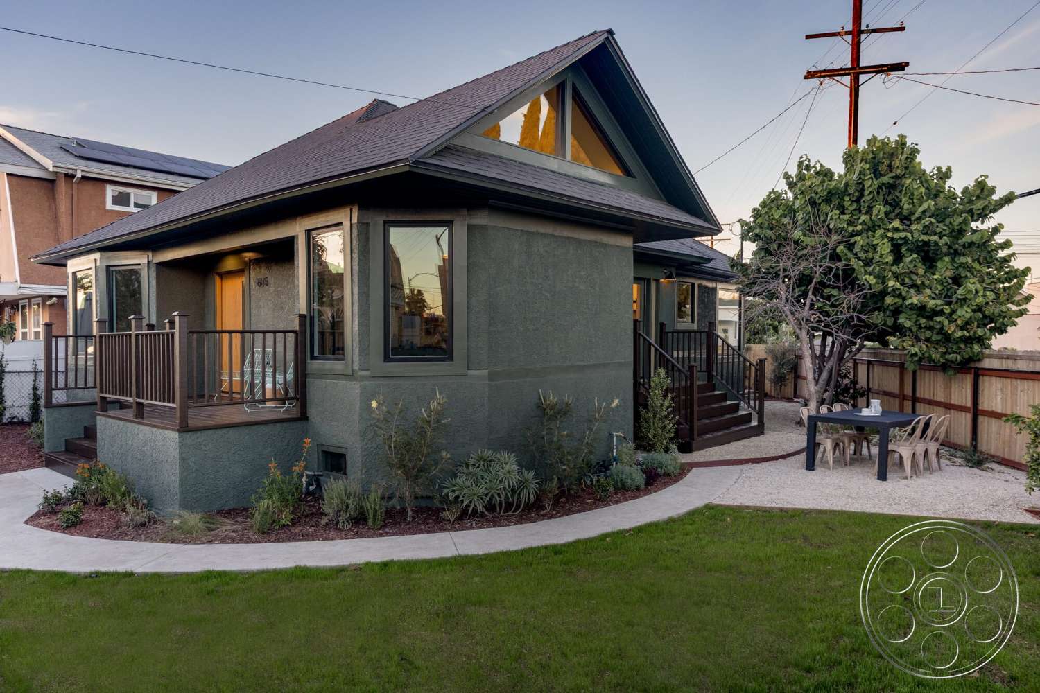 Craftsman 65 - exterior, landscaped garden, flat roof, large glass windows, wooden dining table, outdoor seating area, urban setting, sloped roof, green lawn, concrete walkway, stucco walls, gravel patio flooring, wooden porch railing, decorative gable ends