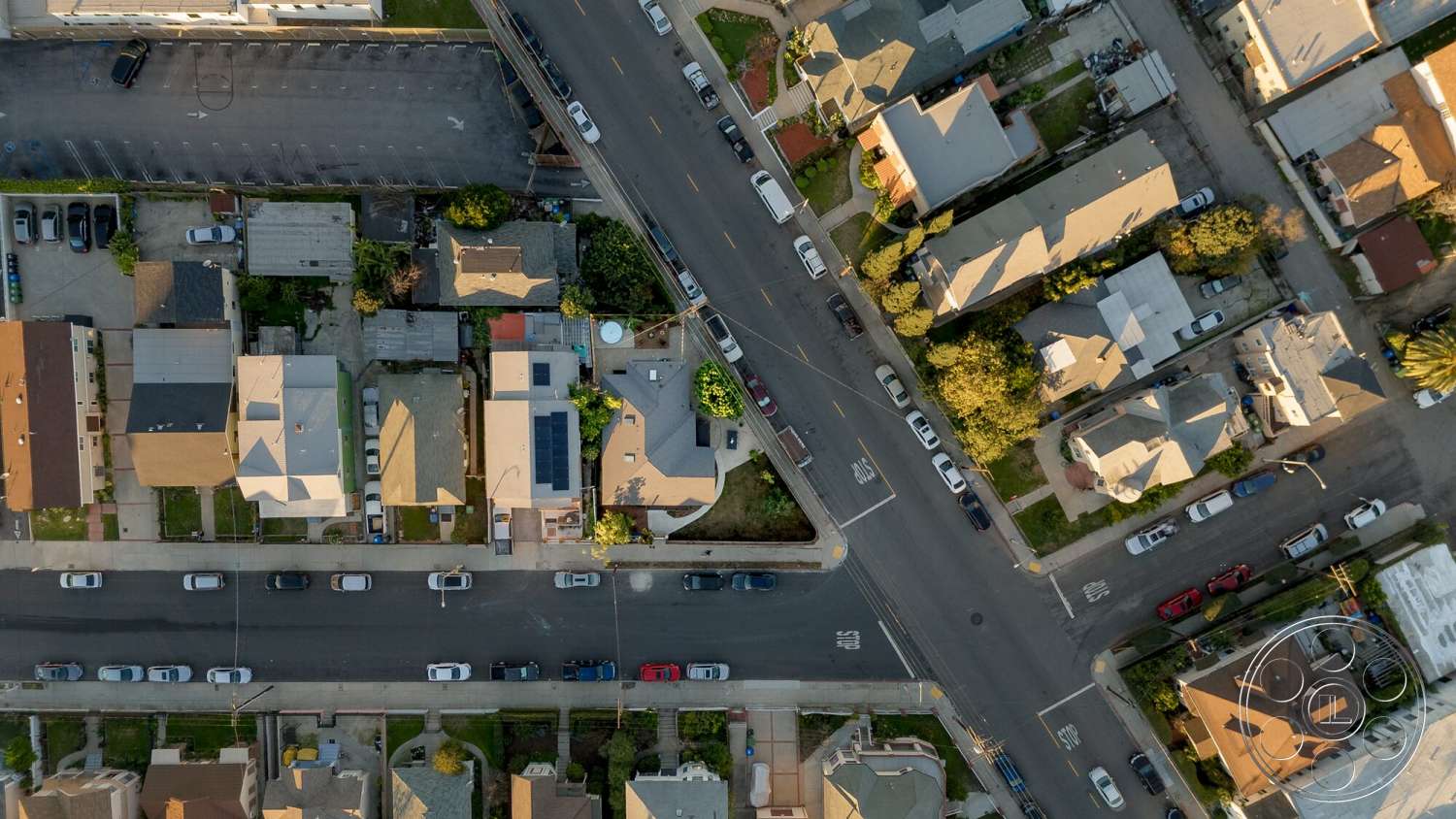 Craftsman 65 - exterior, residential neighborhood, green lawns, urban environment, asphalt road, sidewalks, solar panels on roof, single-story homes, flat rooftops, vehicles parked on street, trees in front yards, open space park, corner lot houses