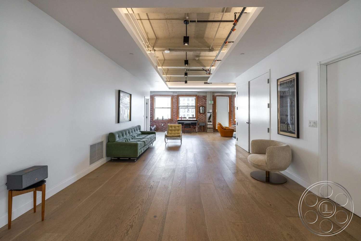 Loft 1 - hardwood flooring, open floor plan, modern furniture, industrial lighting fixtures, concrete ceiling, rectangular layout, white painted walls, exposed brick accent wall
