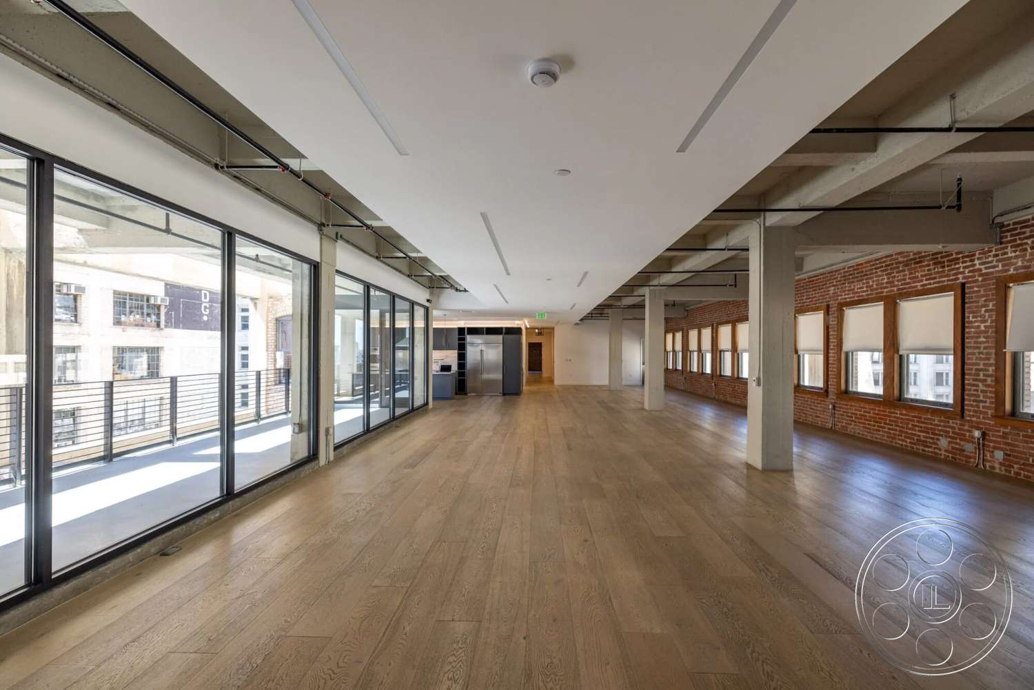 Loft 1 - hardwood flooring, industrial style, exposed brick walls, floor-to-ceiling windows, wooden window frames, open-plan layout, concrete ceiling beams