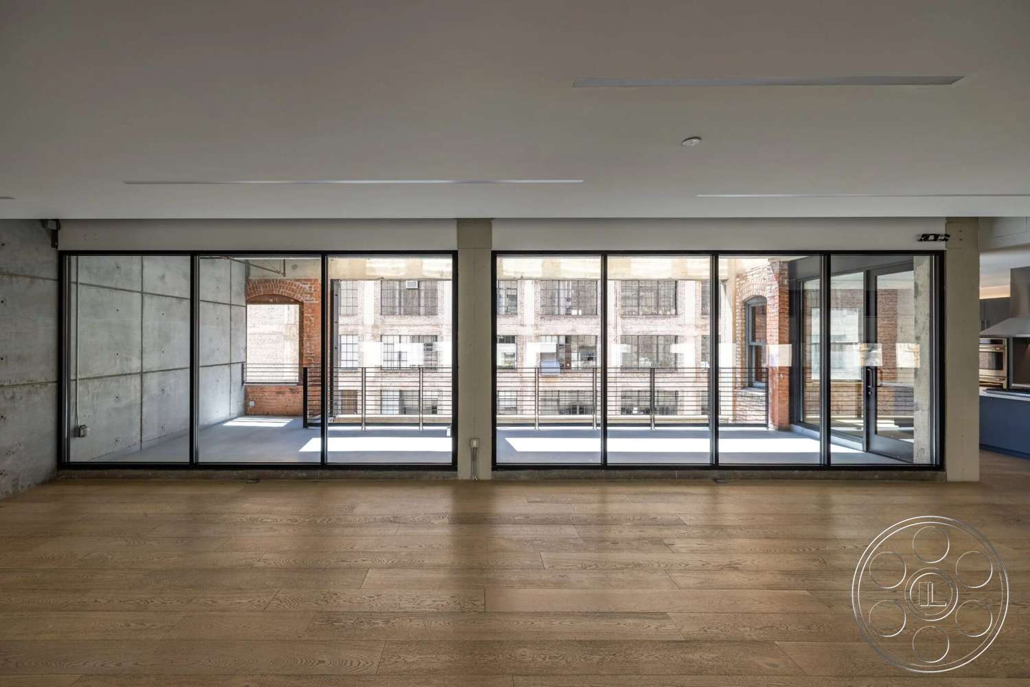 Loft 1 - high ceilings, natural light, wood flooring, contemporary design, large glass sliding doors, open floor plan, natural wood accents, exposed concrete walls, metal railing, urban setting, industrial style interior