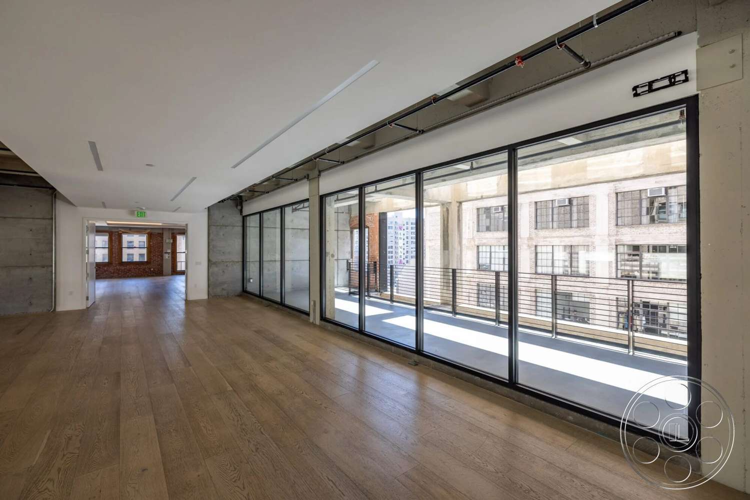 Loft 1 - neutral color palette, hardwood flooring, modern design, open floor plan, metal railings, concrete walls, industrial style, urban setting, floor-to-ceiling windows, exposed concrete ceiling