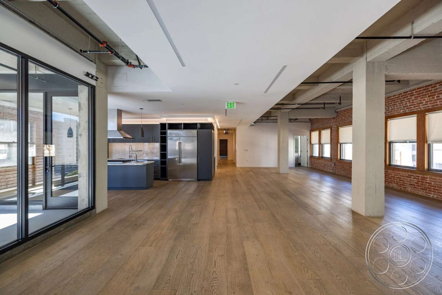 Loft 1 - modern kitchen, neutral color palette, large windows, hardwood flooring, recessed lighting, minimalist design, open floor plan, stainless steel appliances, glass sliding doors, exposed brick walls, industrial style elements, concrete structural columns