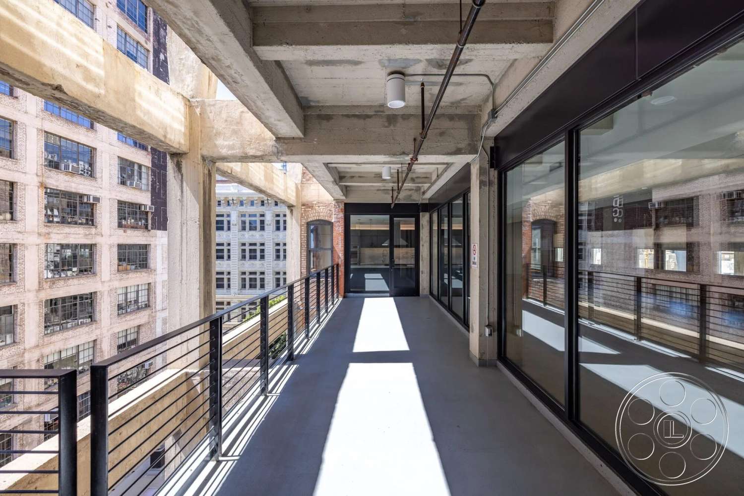 Loft 1 - exterior, urban setting, exposed concrete ceiling, glass partition walls, industrial architectural style, metal railing balcony, exposed brick exterior walls, concrete balcony floor