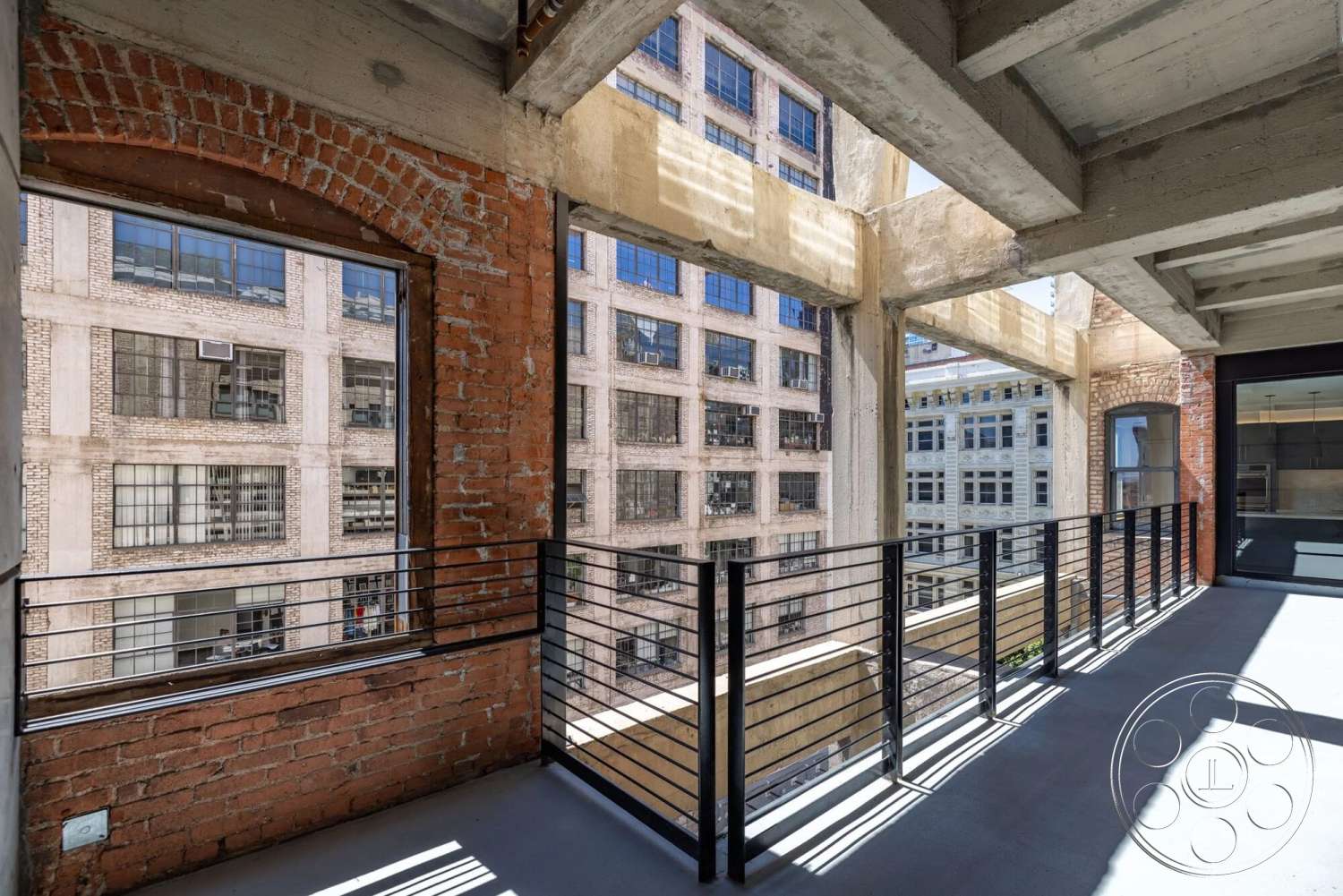Loft 1 - exposed brick walls, urban setting, industrial architecture, glass window frames, concrete ceiling beams, steel railing balcony, concrete balcony floor