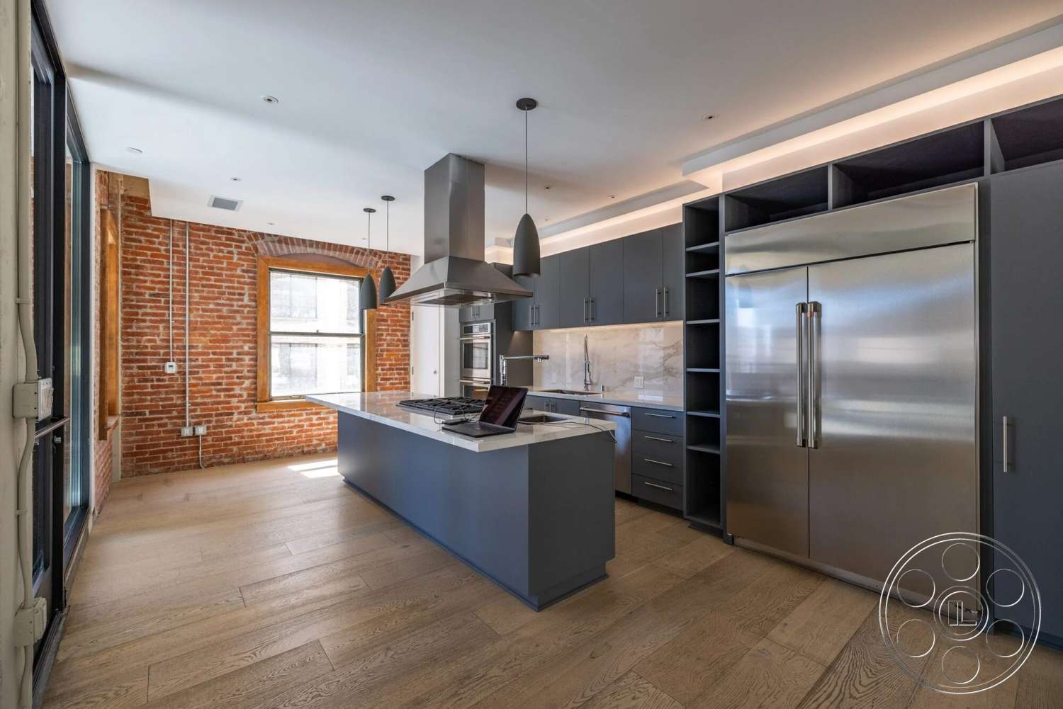 Loft 1 - high ceilings, stainless steel appliances, dark cabinetry, floor-to-ceiling windows, red brick accent wall, metal pendant lighting, modern kitchen design, open concept kitchen, marble kitchen backsplash, light hardwood kitchen floors, industrial style kitchen, wooden kitchen island countertop, exposed piping details