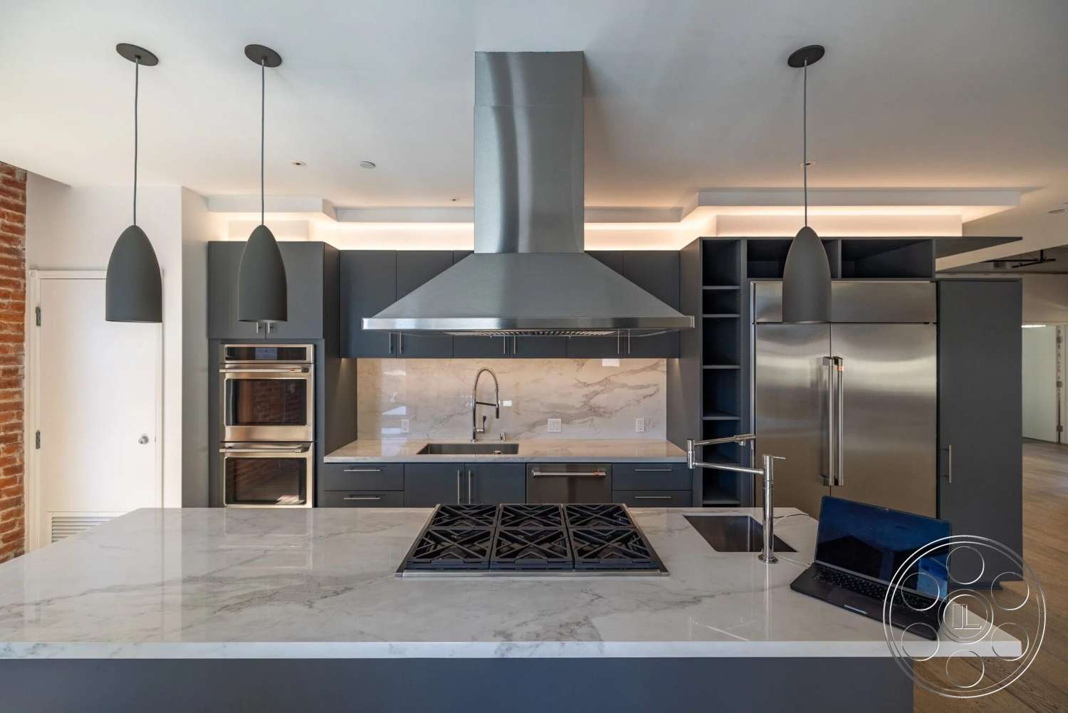 Loft 1 - wood flooring, minimalist design, stainless steel appliances, open shelving, dark cabinetry, kitchen island, industrial style, marble countertop, glass backsplash, built-in oven, pendant lighting fixtures, modern kitchen layout, exposed brick accent wall, smooth ceiling finish, integrated refrigerator, high-efficiency range hood, cooktop with grates