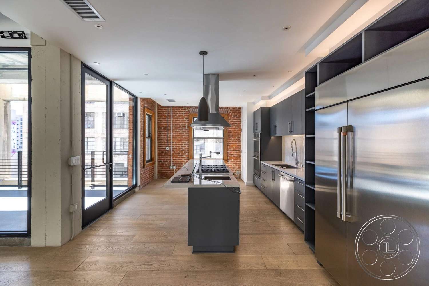 Loft 1 - stainless steel appliances, modern pendant lighting, kitchen island, industrial style, floor-to-ceiling windows, sleek cabinetry, concrete ceiling, open-concept layout, modern kitchen design, exposed brick accent wall, wood plank flooring, contemporary countertops