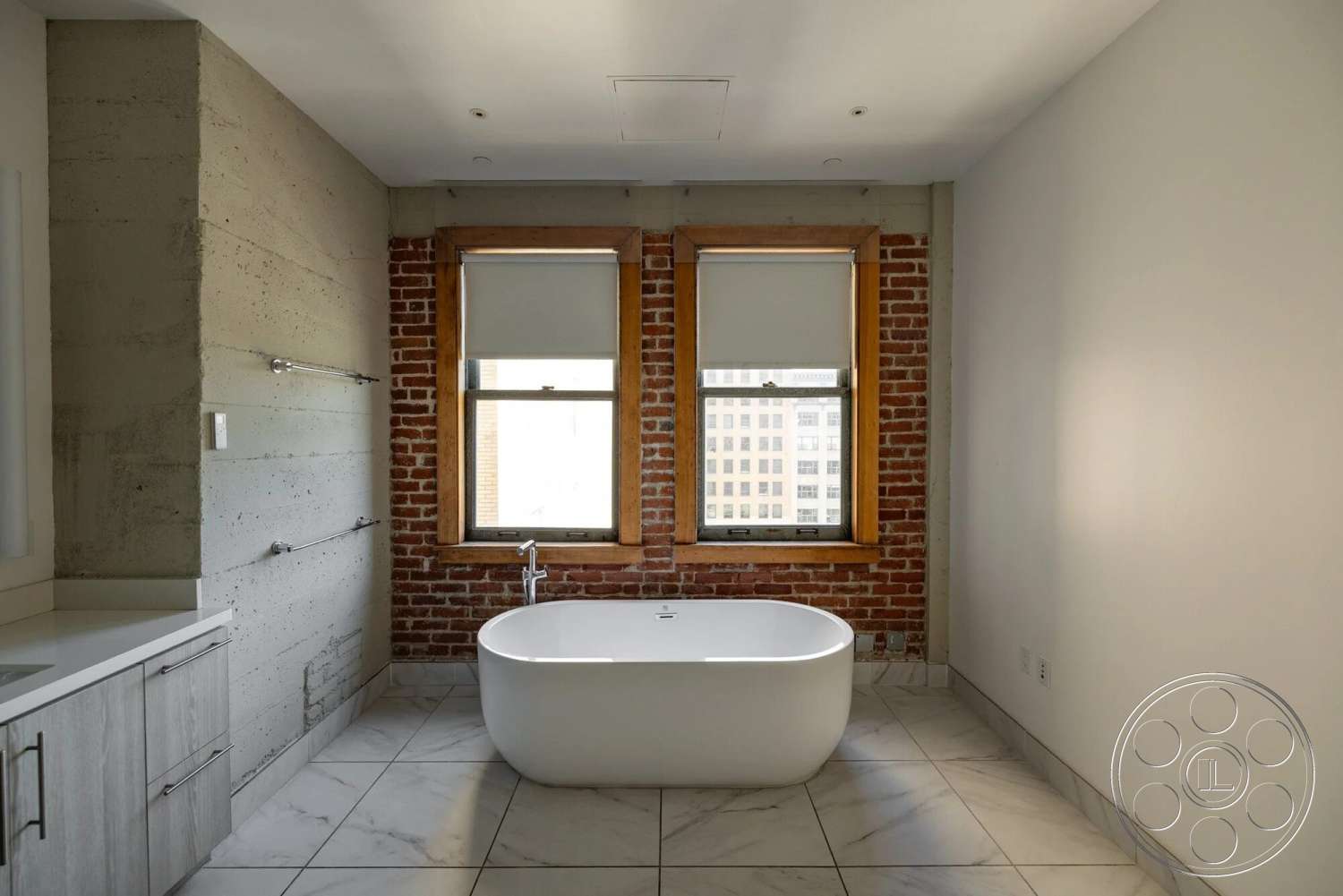 Loft 1 - minimalist design, freestanding bathtub, exposed brick wall, wood window frames, marble bathroom flooring, concrete accent wall, modern bathroom cabinetry, chrome towel bar, soft close bathroom drawers, sliding bathroom mirrors