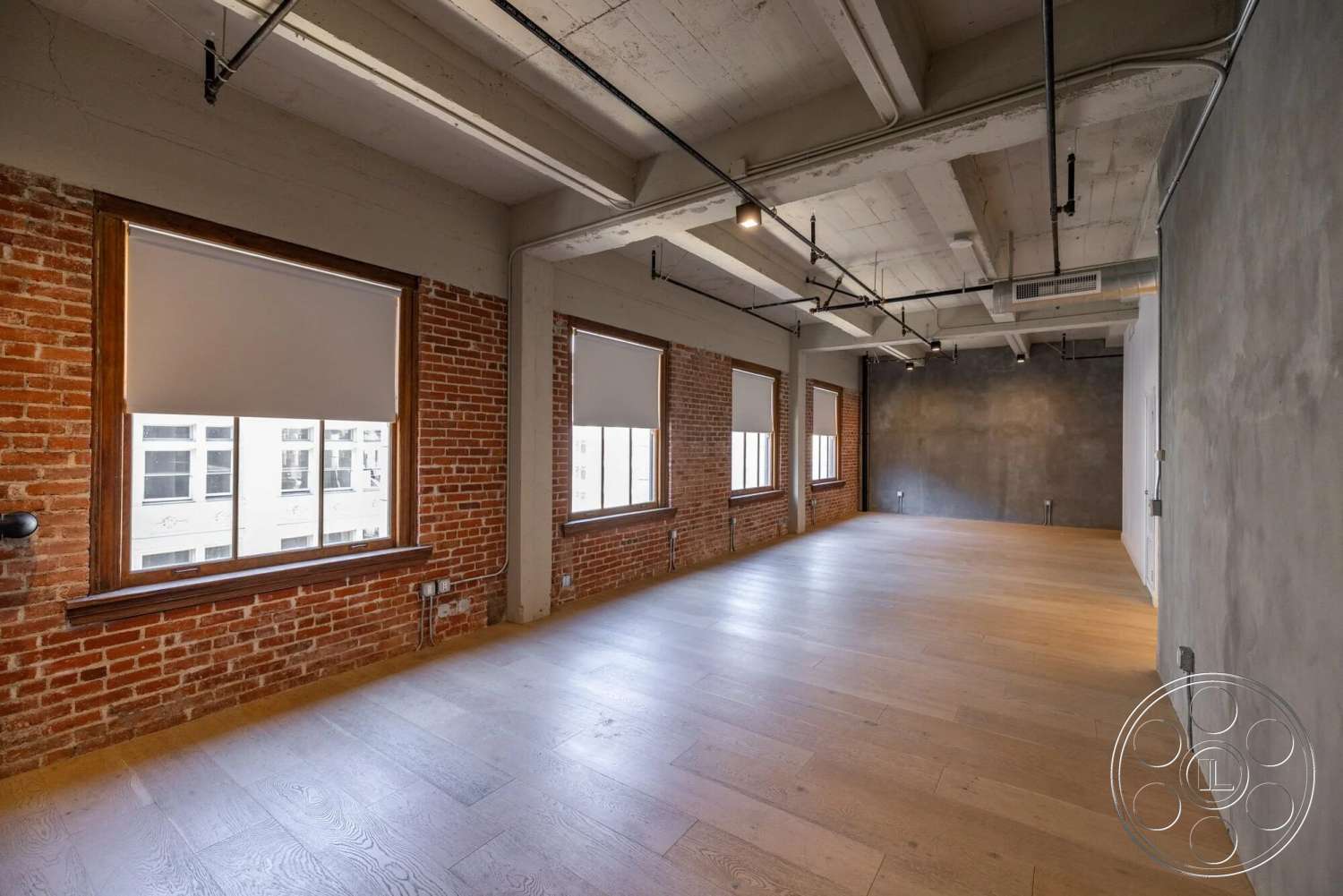 Loft 1 - hardwood flooring, open floor plan, modern light fixtures, industrial style, floor-to-ceiling windows, concrete ceiling, natural light sources, minimalist interior, exposed brick accent walls, metal piping details