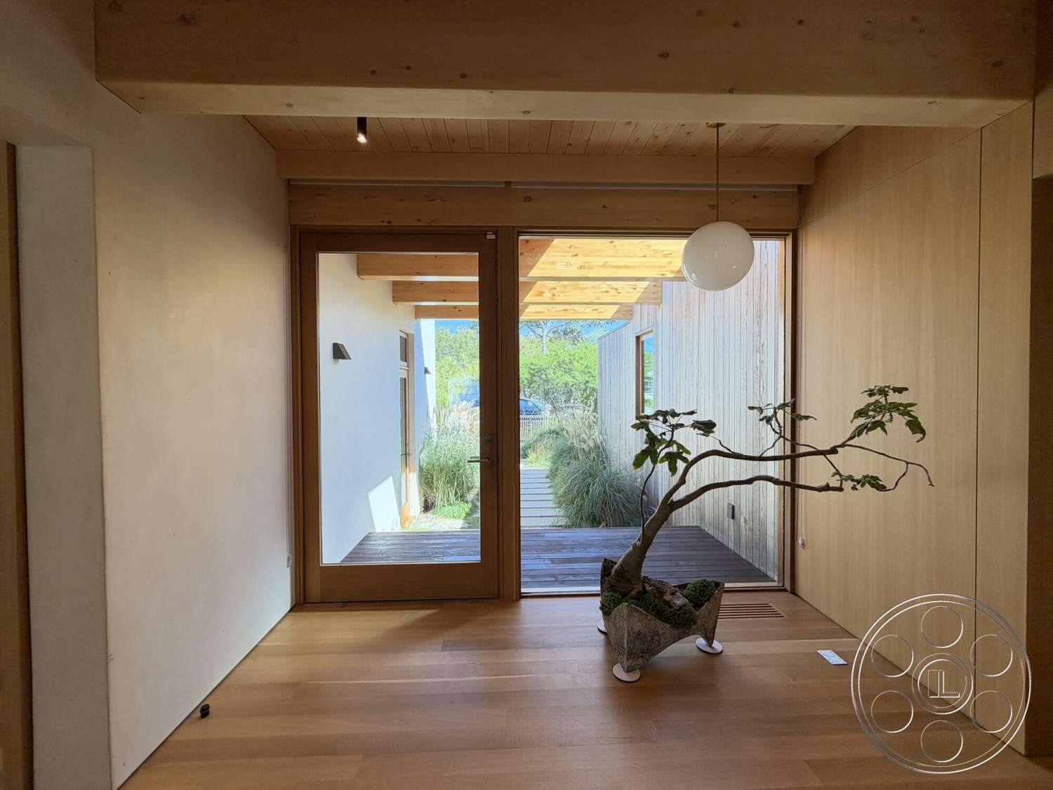 Retro House - pendant light fixture, exposed wood ceiling beams, hardwood entryway floors, smooth plaster walls, natural light corridor, glass front door, integrated indoor plant display