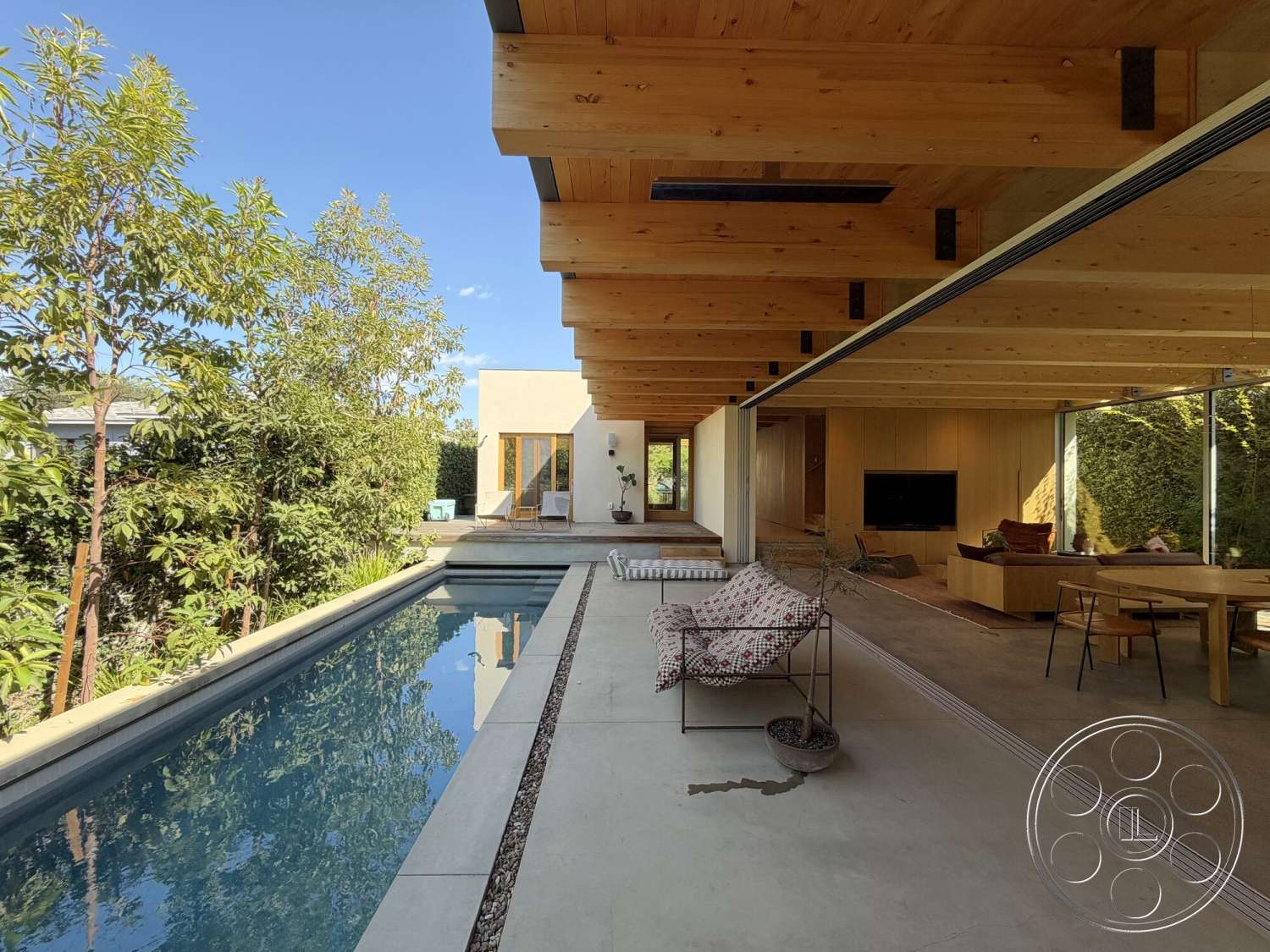 Retro House - natural light, exterior, landscaped garden, minimalist design, large glass sliding doors, wood dining table, floor-to-ceiling windows, modern architectural style, rectangular pool, wooden lounge chair, exposed wood ceiling beams, open concept living area, concrete pool border, greenery landscape, textured concrete patio floor
