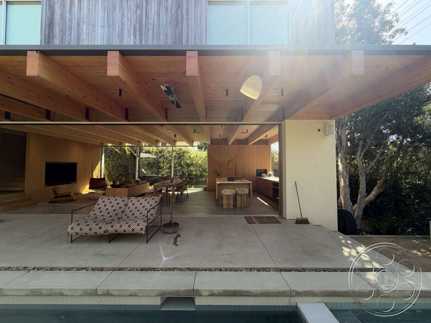 Retro House - natural light, exterior, landscaped garden, large glass sliding doors, wood dining table, surrounding greenery, minimalist furniture, wood accent walls, modern outdoor seating, contemporary architectural style, exposed wood ceiling beams, rectangular kitchen island, concrete patio floor, open living area, sliding glass partition
