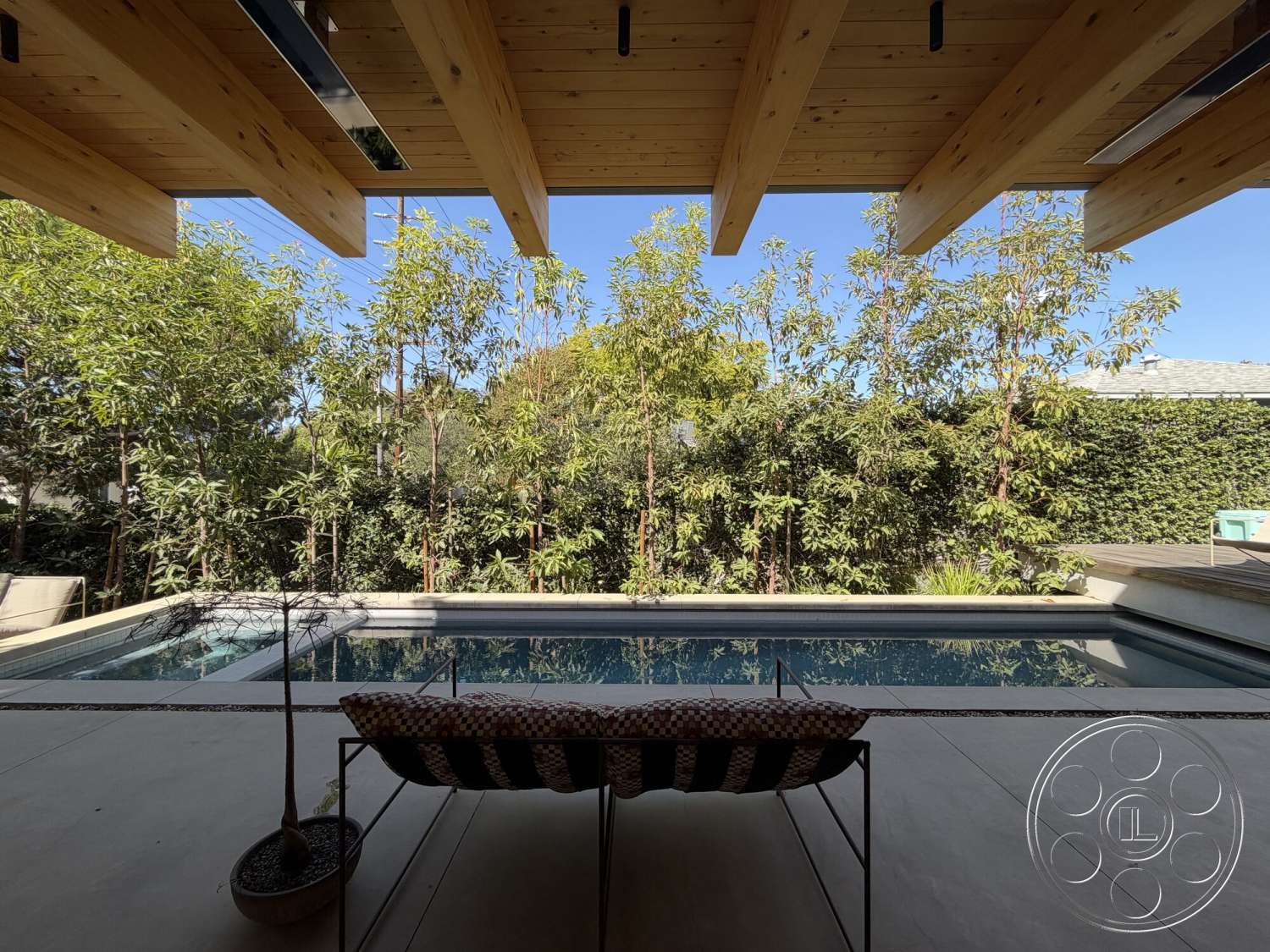 Retro House - rectangular swimming pool, tropical setting, modern outdoor area, lush green landscaping, wooden lounge chair, concrete patio flooring, exposed wood beam ceiling