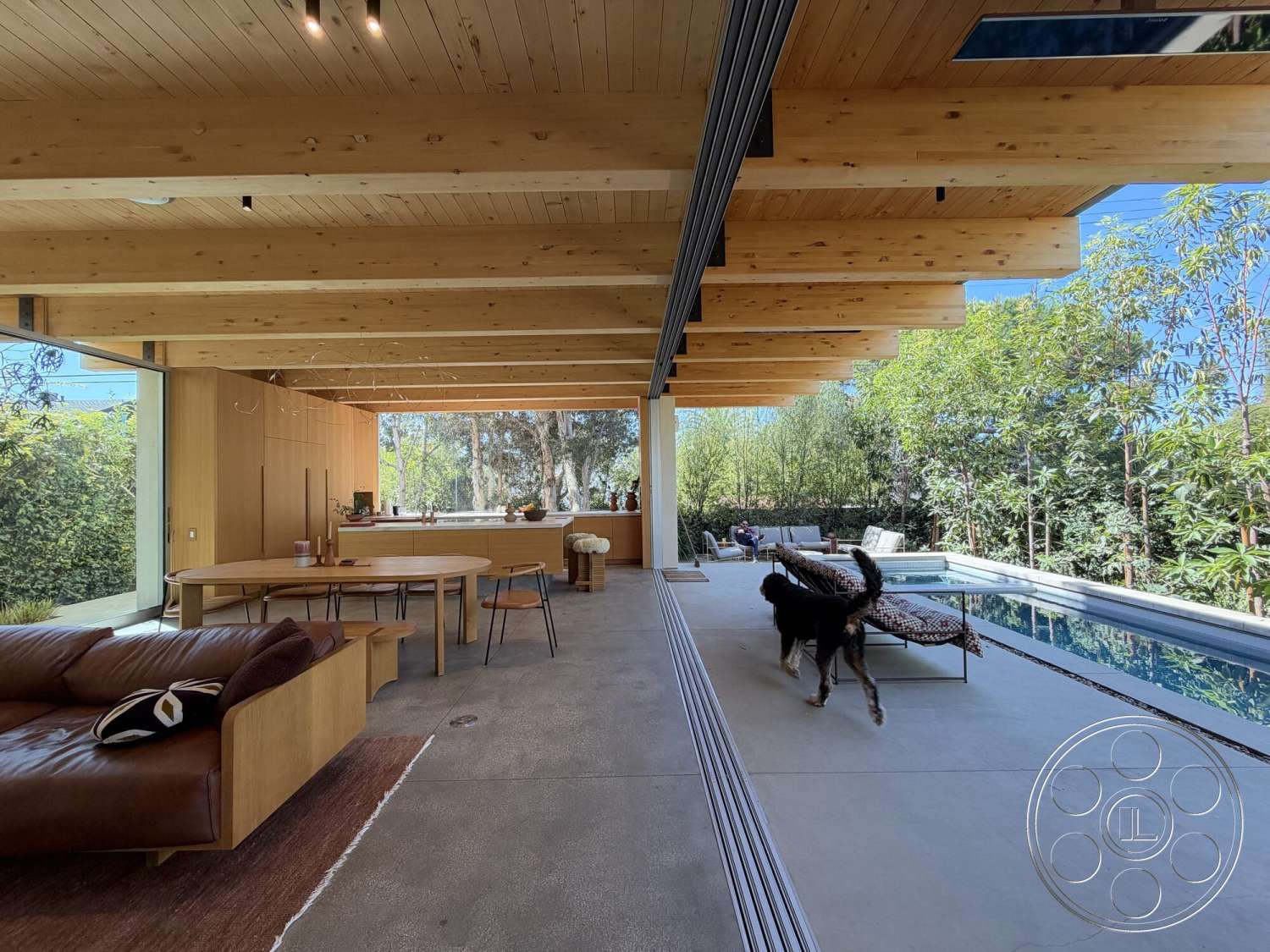 Retro House - natural light, minimalist design, open floor plan, concrete flooring, wood dining table, outdoor greenery, floor-to-ceiling windows, mid-century modern furniture, light wood paneling, exposed wood ceiling beams, decorative indoor plants, contemporary dining chairs, comfortable leather sofa, pool area view, modern kitchen setup